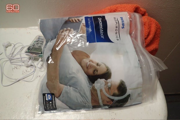 Foto de una bolsa con la máquina CPAP de Epstein y sus audífonos personales. La mascarilla solo aparece en algunas imágenes
