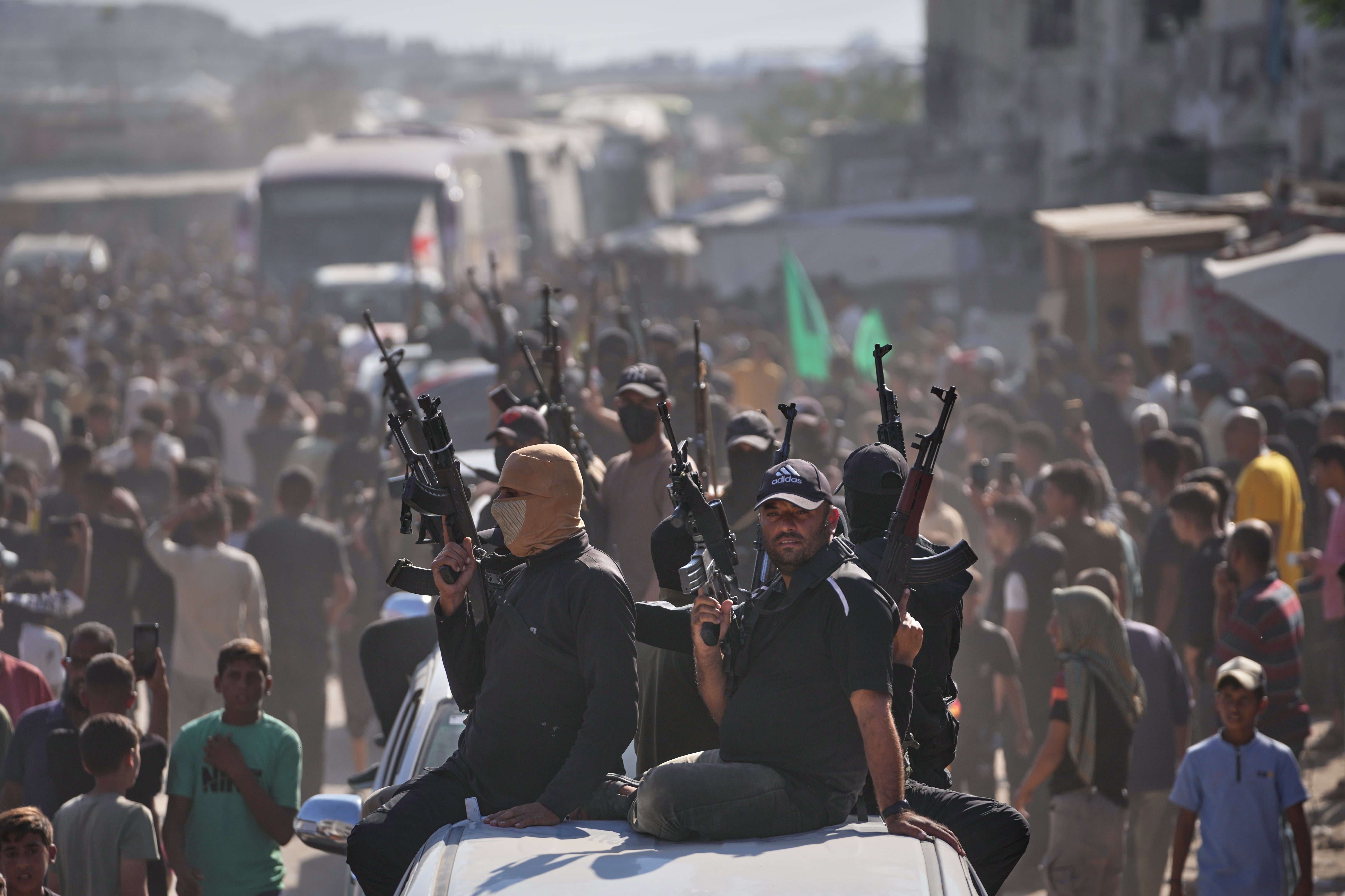 Milicianos de Hamás escoltan en camionetas a los autobuses con palestinos liberados, que son recibidos tras salir de prisiones israelíes