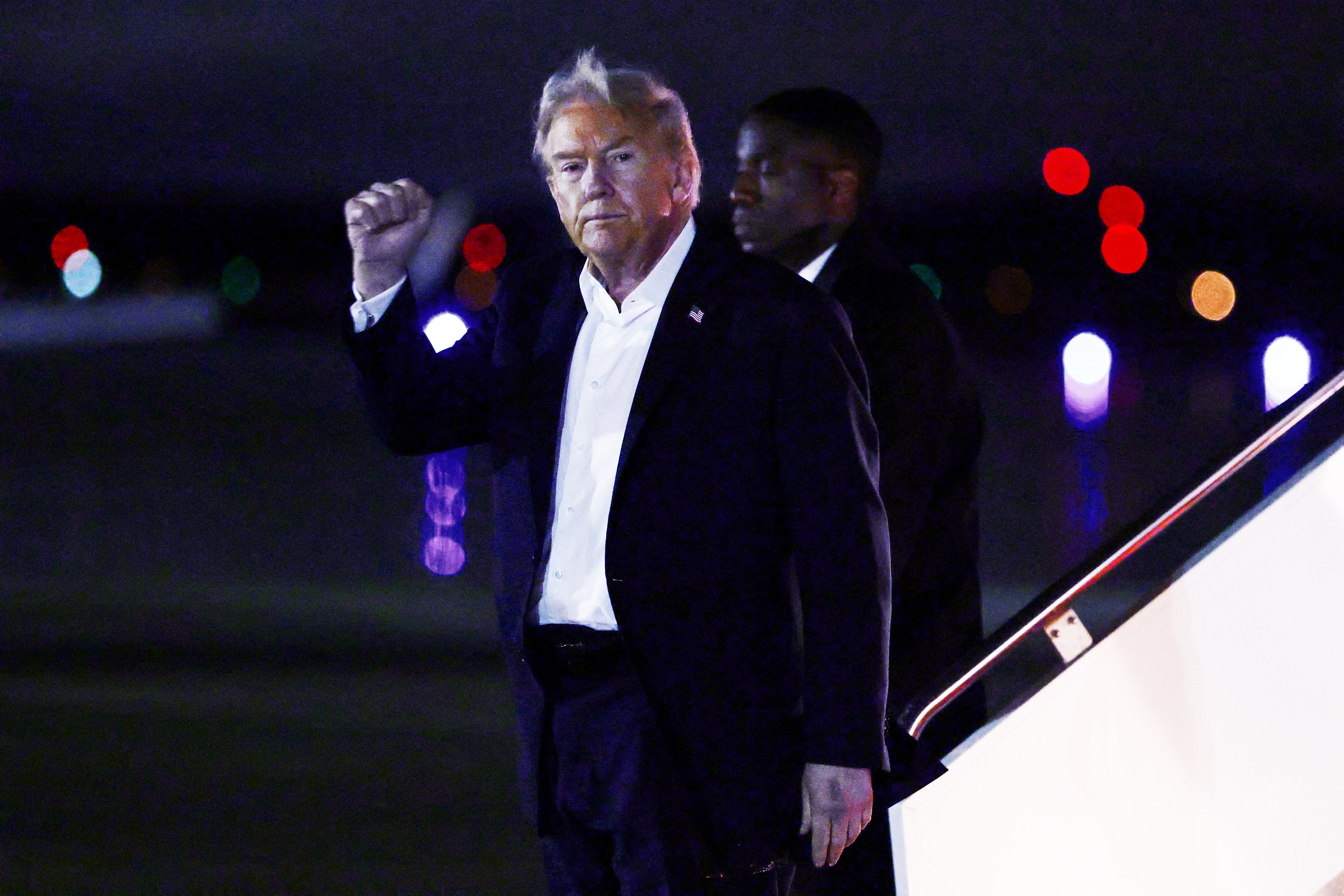 Donald Trump gesticula al bajar del Air Force One tras regresar de la cumbre en Egipto