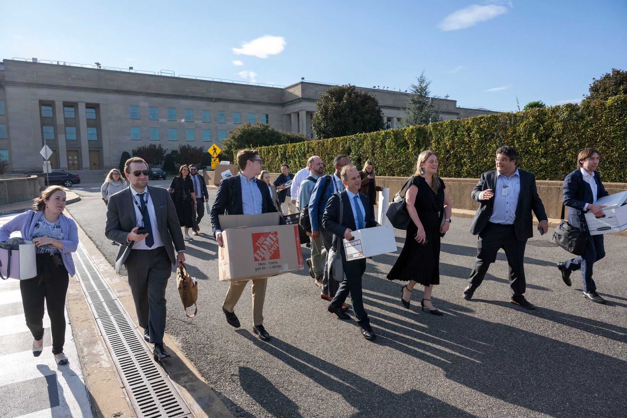 Miembros del cuerpo de prensa del Pentágono sacan sus pertenencias del Pentágono tras entregar sus credenciales de prensa, el miércoles 15 de octubre de 2025 en Washington. (AP Photo/Kevin Wolf)