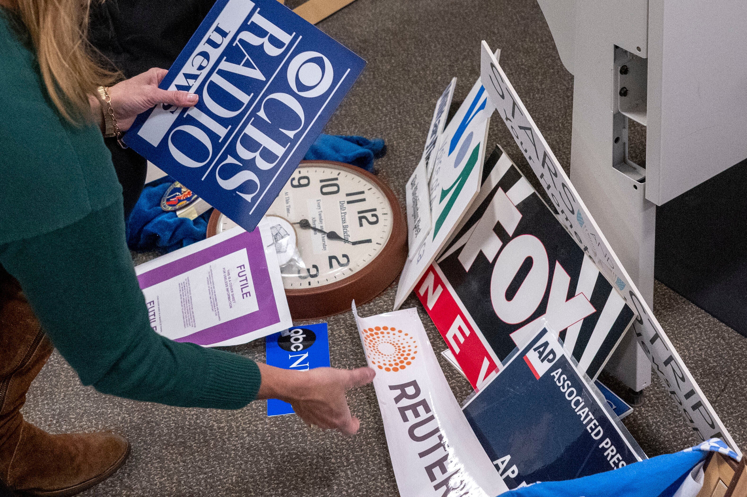 La reportera del Washington Post, Tara Copp, guarda las placas con los nombres de varias organizaciones de noticias mientras ella y los miembros de los medios de comunicación recogen sus pertenencias en la zona de prensa del Pentágono, el miércoles 15 de octubre de 2025