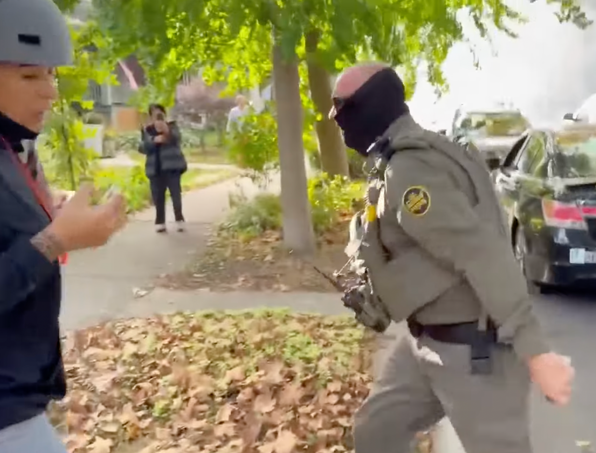 Un agente empuja a la multitud en medio de una redada en un vecindario de Irving Park
