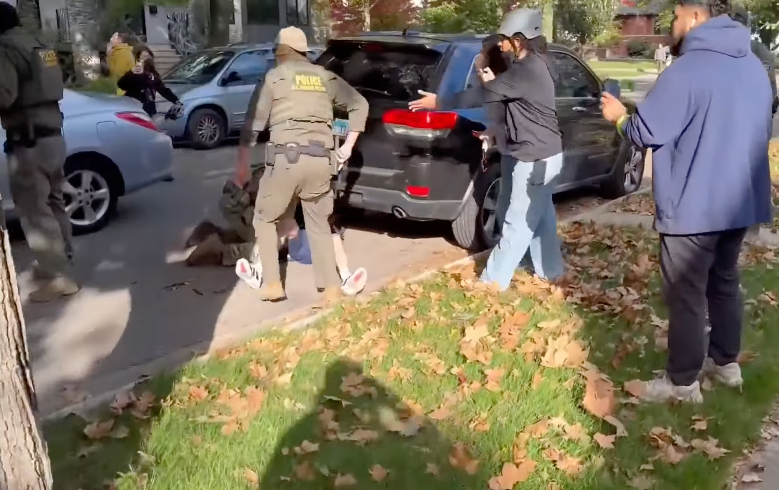 La multitud se congregó en torno al hombre mientras los agentes lo tiraban al suelo