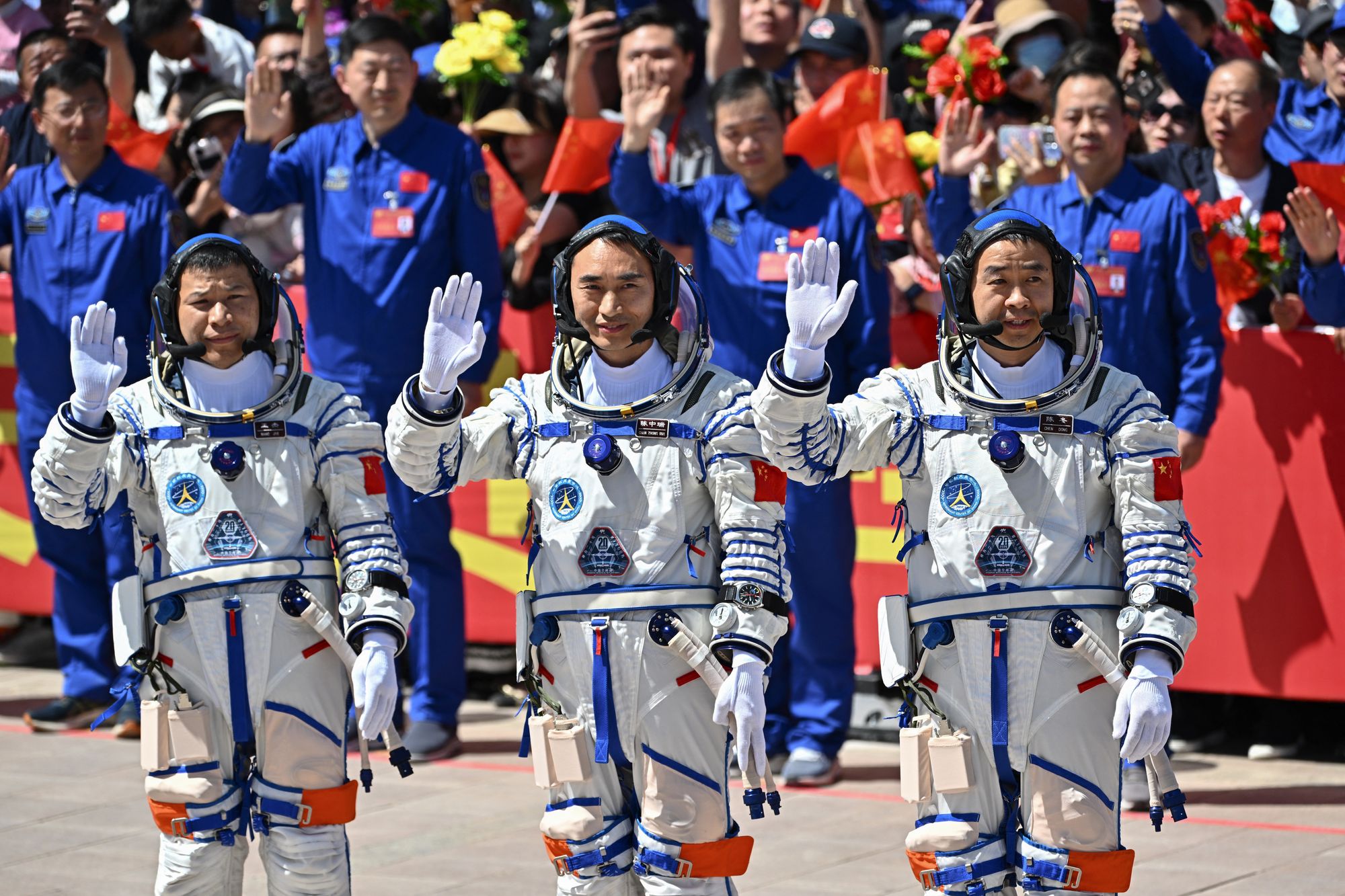 La misión espacial china Shenzhou-20 (de izquierda a derecha) Wang Jie, Chen Zhongrui y Chen Dong, saludan durante una ceremonia de partida