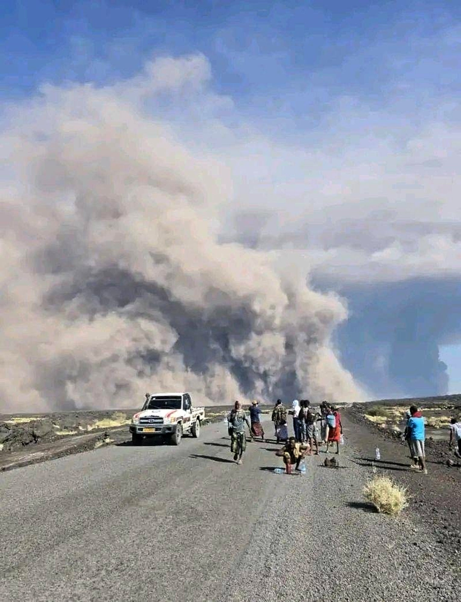 Varios habitantes de la región de Afar observan la nube de ceniza procedente del volcán Hayli Gubbi