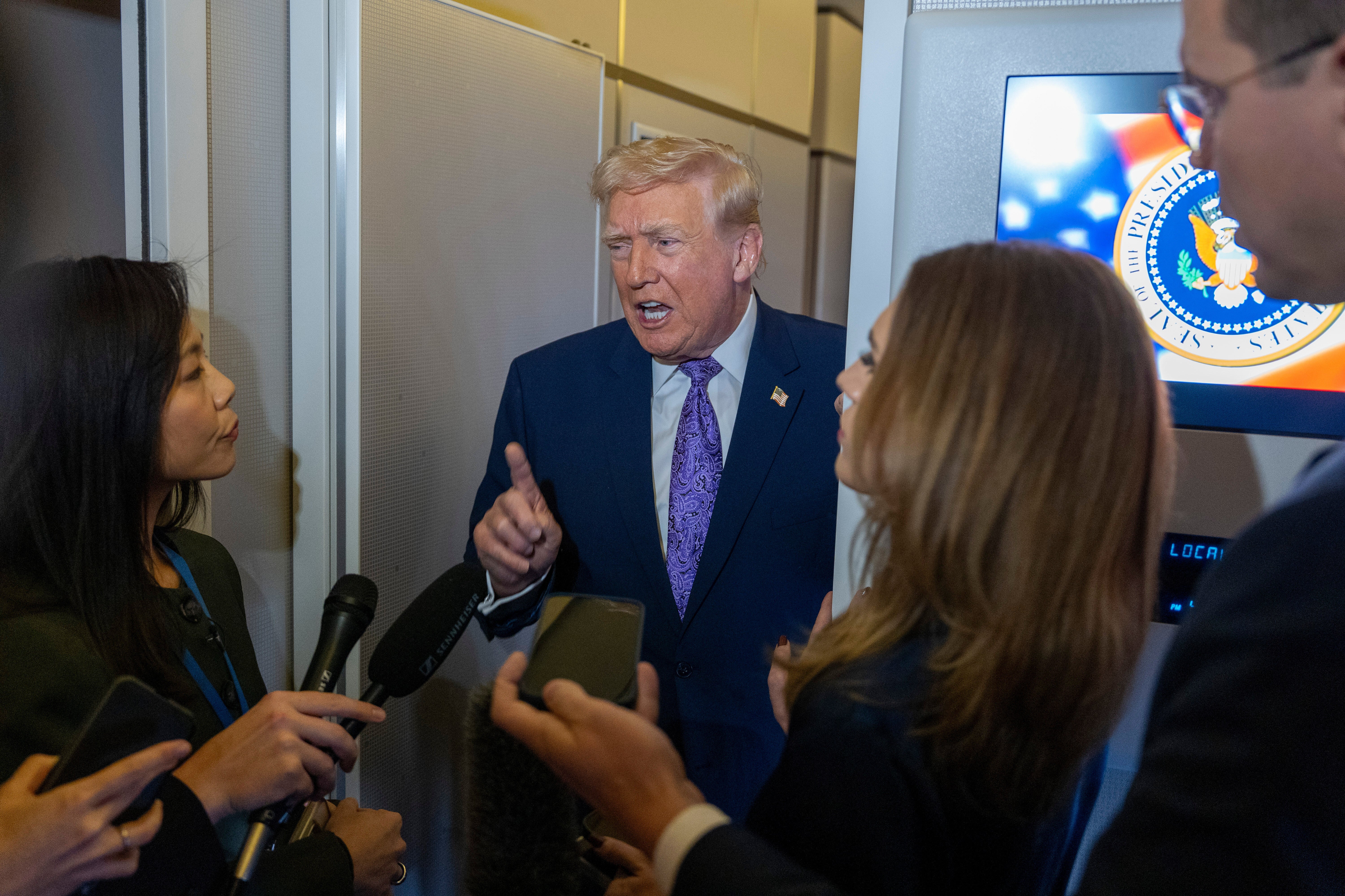 Trump habla con reporteros a bordo del Air Force One la noche del domingo