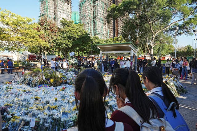 <p>Personas dejan flores en un memorial improvisado cerca del complejo Wang Fuk Court, en Tai Po, Hong Kong, el 1 de diciembre</p>
