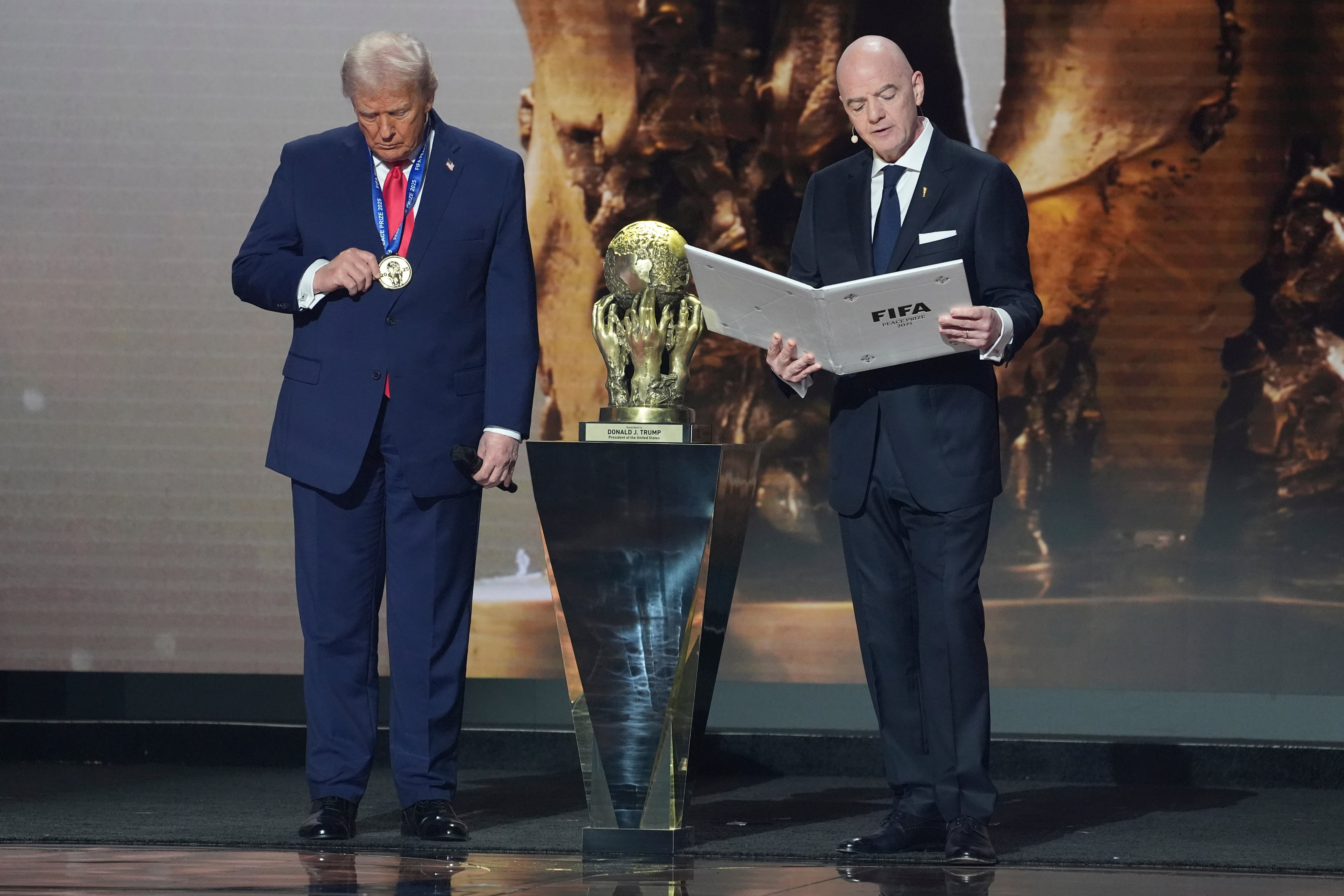 <p>Donald Trump observa su medalla después de ganar el primer Premio de la Paz de la FIFA</p>