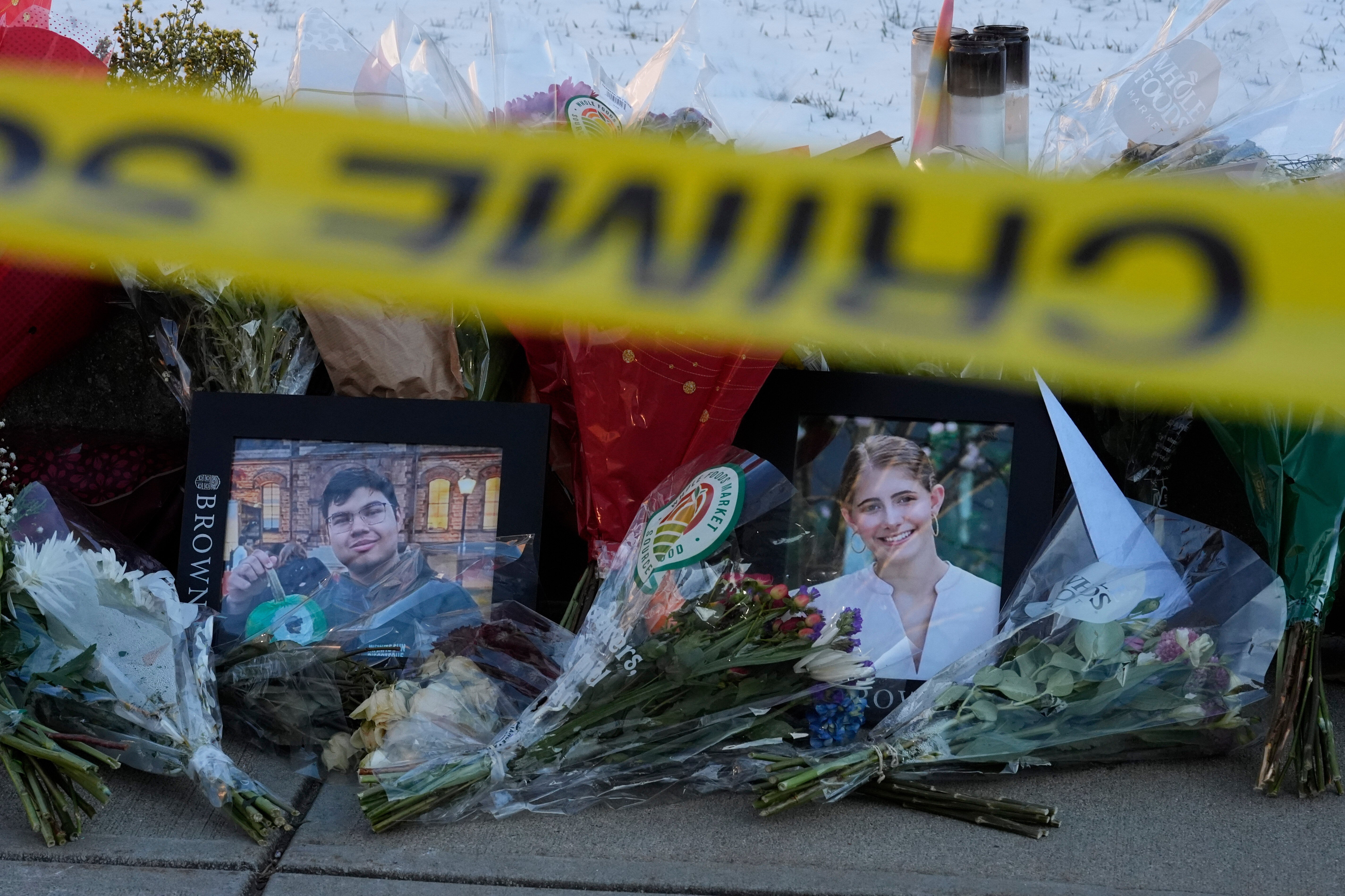 Fotos de Mukhammad Aziz Umurzokov y Ella Cook junto a ramos de flores en un monumento conmemorativo en el campus de la Universidad Brown