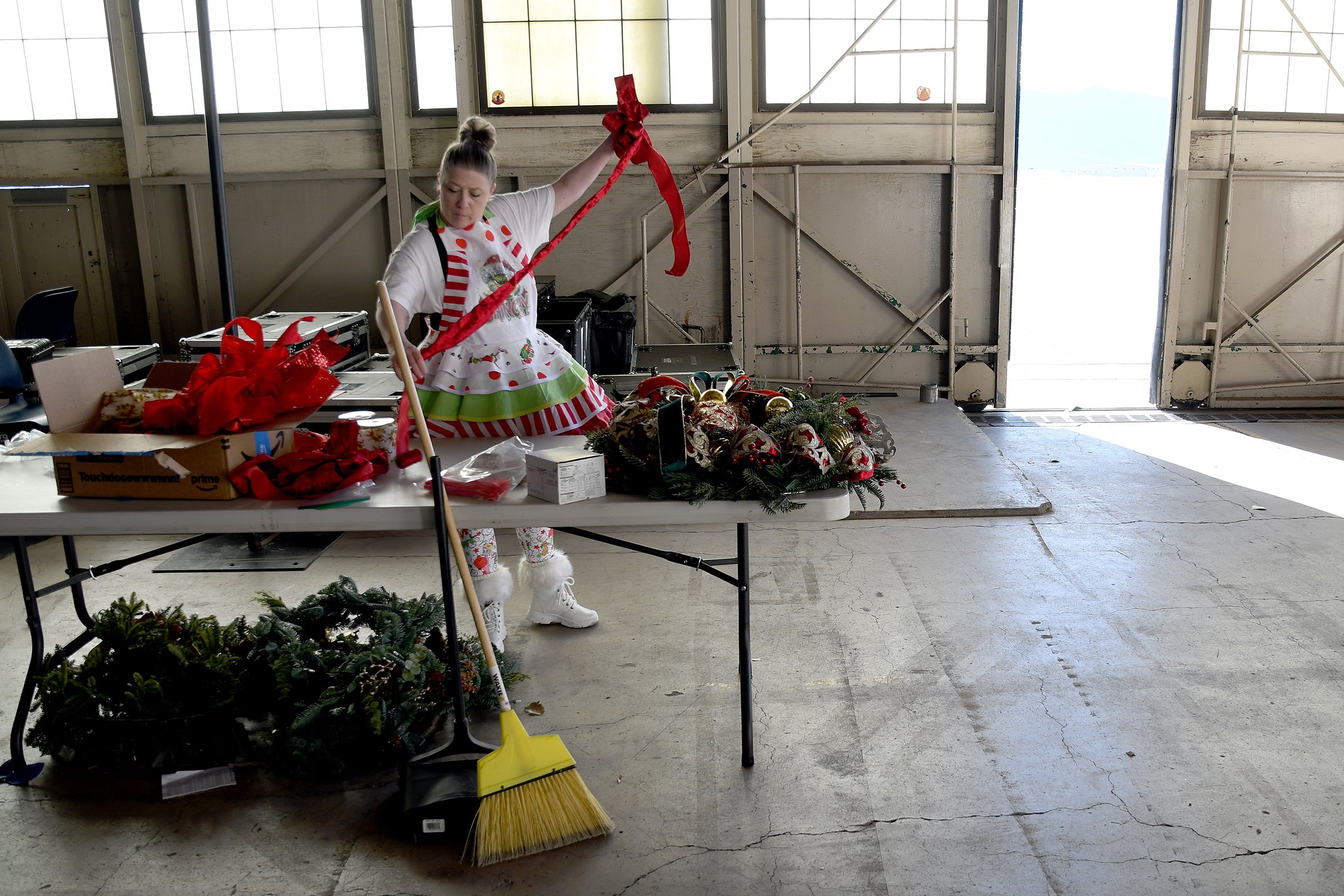 La diseñadora Michelle Reid prepara decoraciones navideñas dentro de un hangar en la Base Espacial Peterson