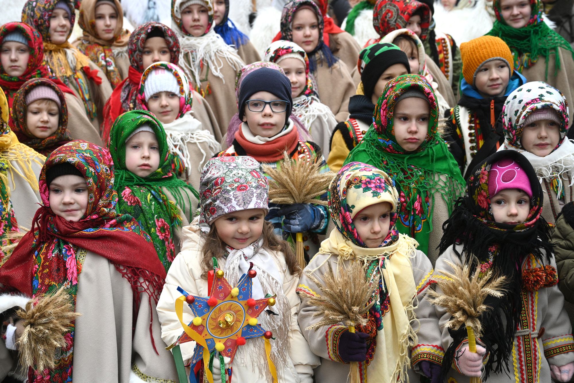 Niños vestidos con ropas tradicionales y portando adornos navideños tradicionales ucranianos o “didukh”, participan en una procesión de Nochebuena en Lviv, o Leópolis en español, el 24 de diciembre de 2025