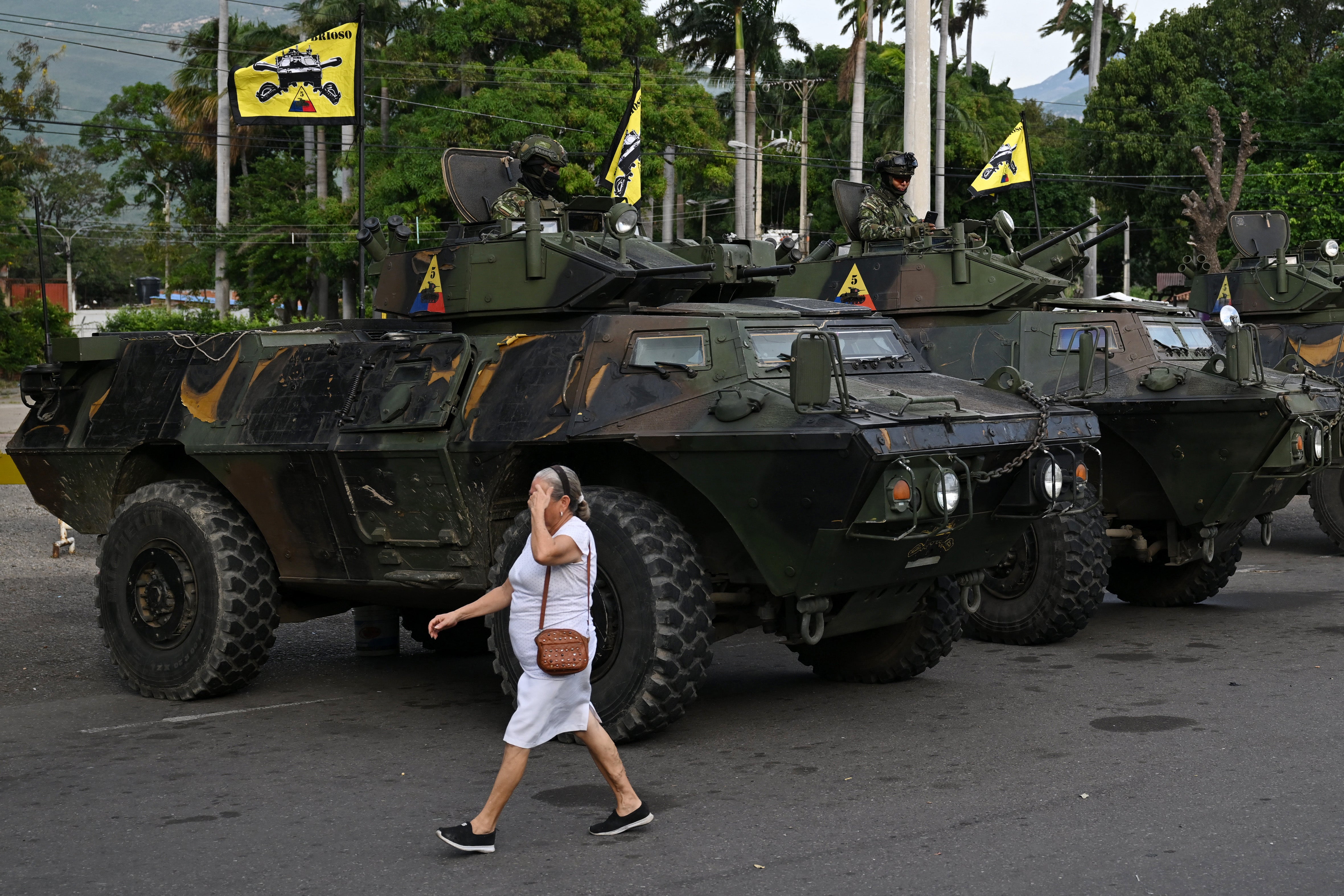 <p>Una mujer pasa junto a vehículos militares en el paso fronterizo con Venezuela en Cúcuta, Colombia </p>