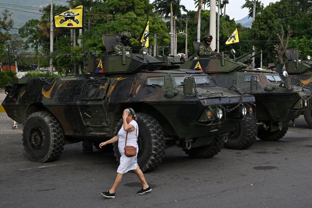 <p>Una mujer pasa junto a vehículos militares en el paso fronterizo con Venezuela en Cúcuta, Colombia </p>