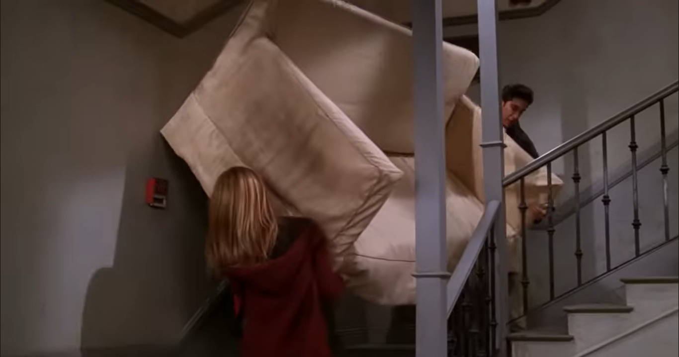 <p>Escena de 'Friends' en la que los personajes luchan por mover un sofá</p>