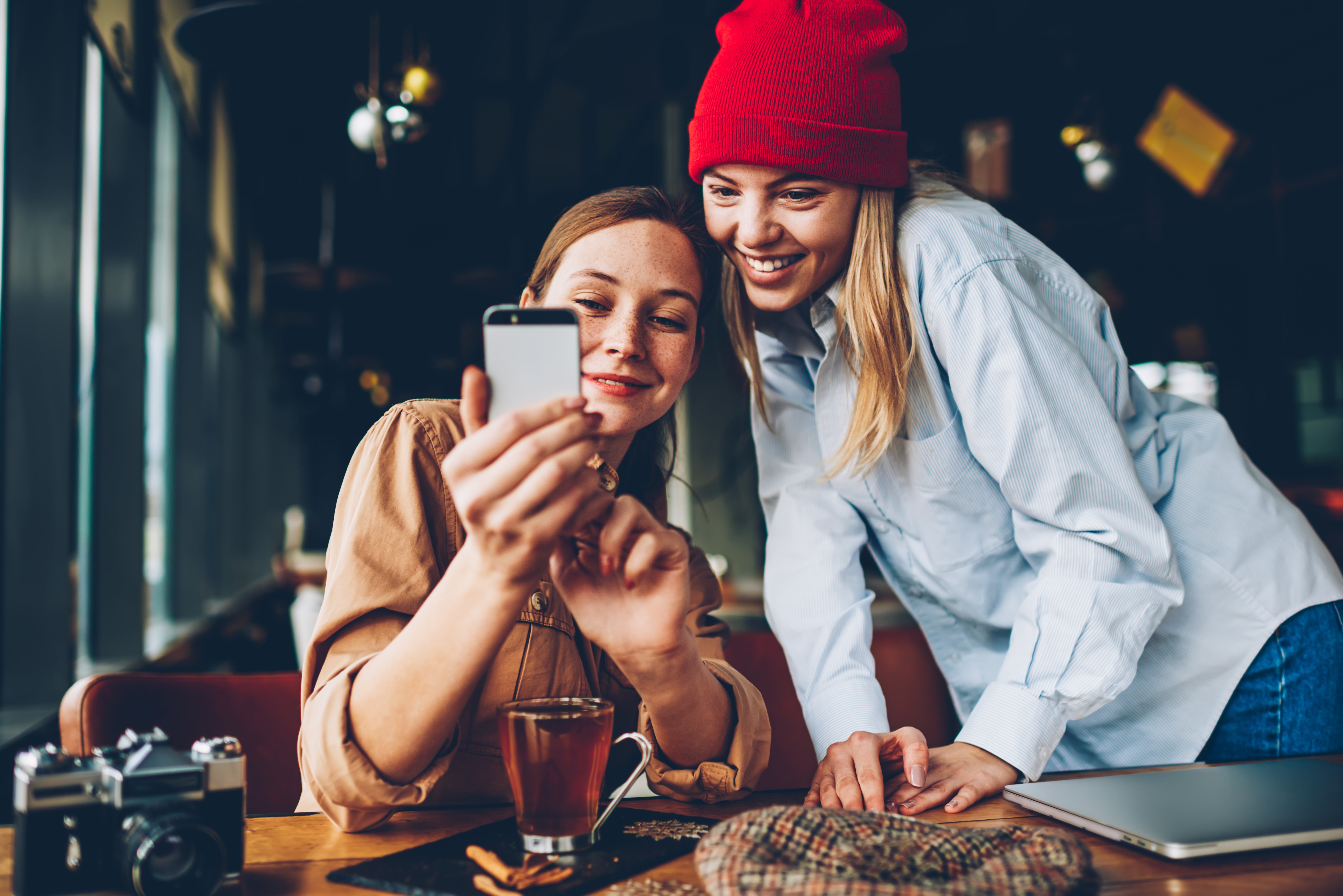 Dos chicas usando un teléfono celular