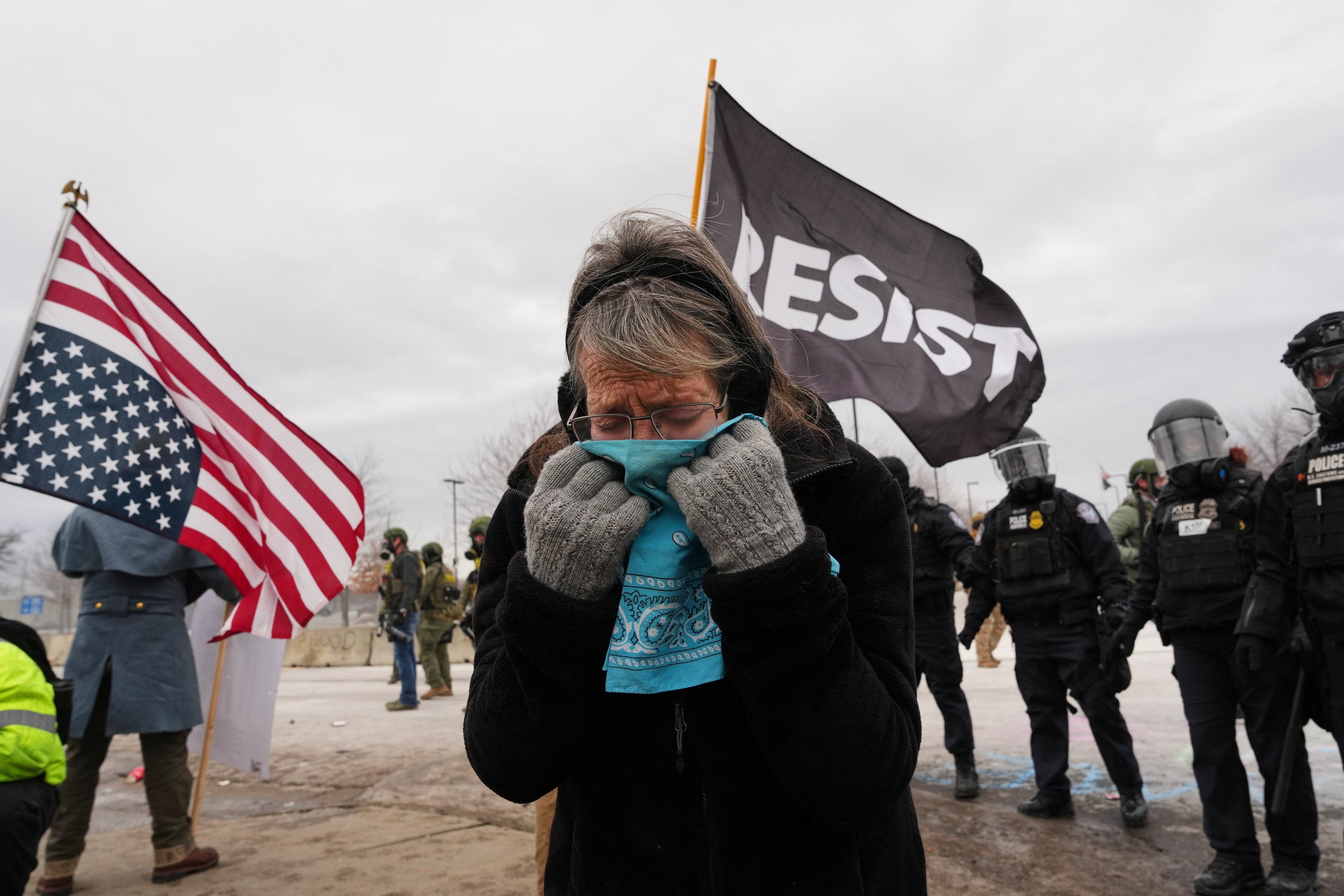 Una mujer se cubre la cara por los gases lacrimógenos mientras funcionarios federales de inmigración se enfrentan a manifestantes ante el edificio federal Bishop Henry Whipple, en Minneapolis, el 15 de enero