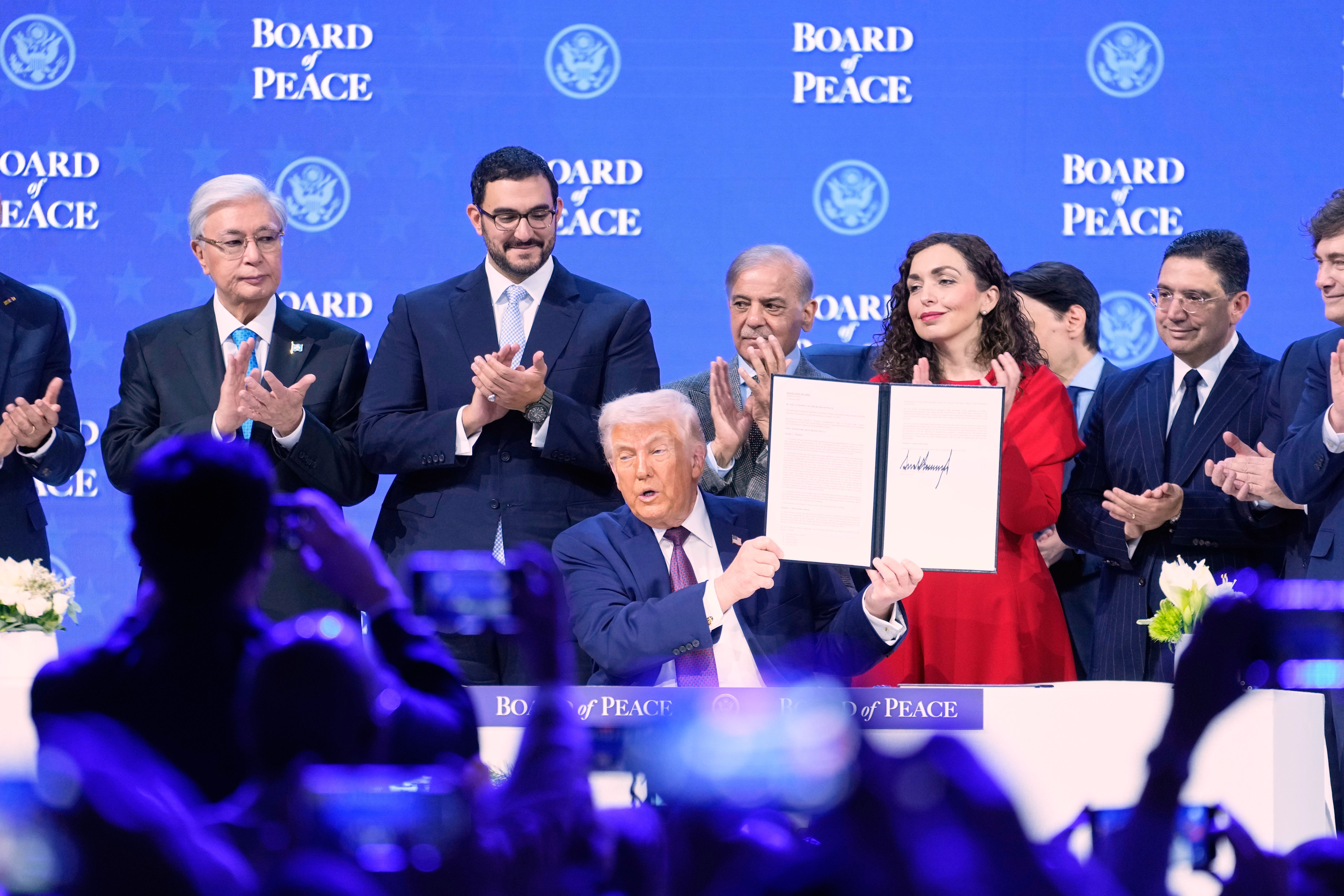 <p>Donald Trump sostiene la carta estatutaria de su Junta de Paz durante una ceremonia de inauguración en el Foro Económico Mundial</p>