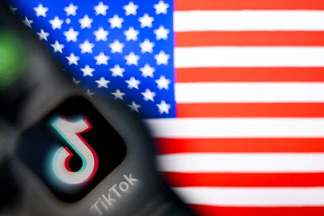 <p>Logotipo de TikTok en la pantalla de un teléfono inteligente e ilustración de la bandera estadounidense en la pantalla de una computadora portátil en Fráncfort del Meno, Alemania, el 10 de abril de 2025</p>