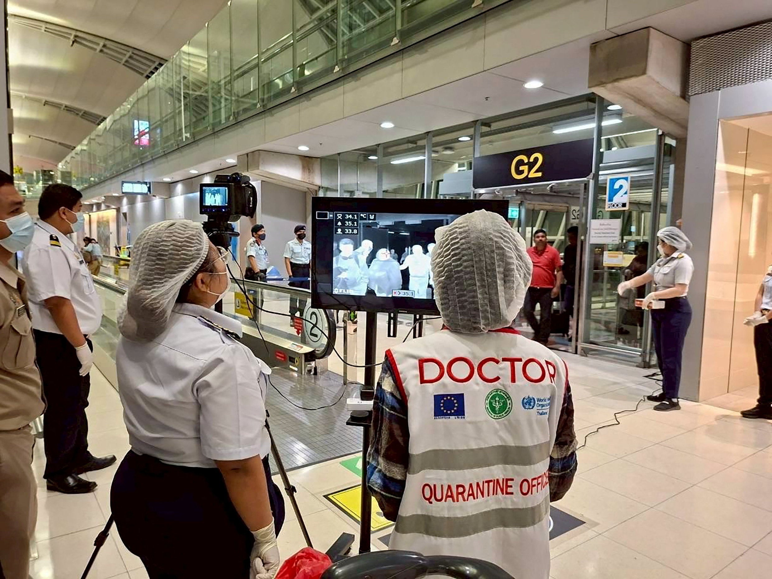 Las autoridades sanitarias del aeropuerto, con mascarillas protectoras, controlan a los pasajeros que llegan al aeropuerto internacional de Suvarnabhumi, en Bangkok, Tailandia