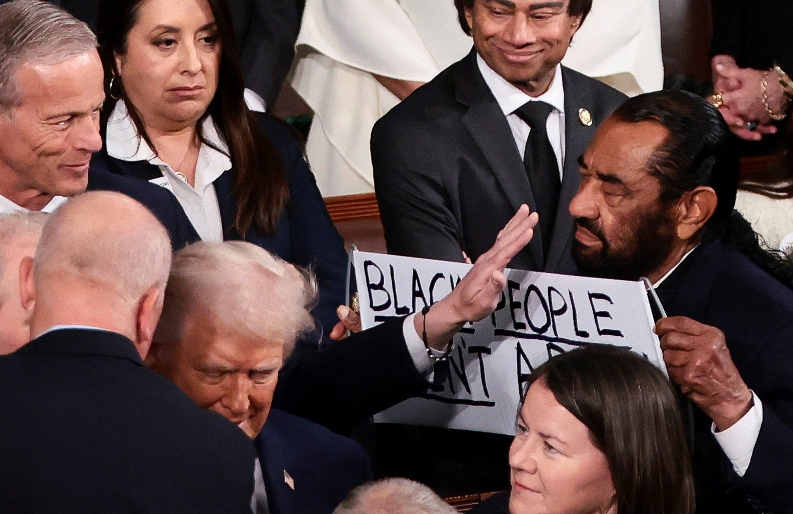 El cartel era una aparente referencia a un video racista generado por inteligencia artificial que Trump publicó en Internet en el que aparecían los Obama representados como primates