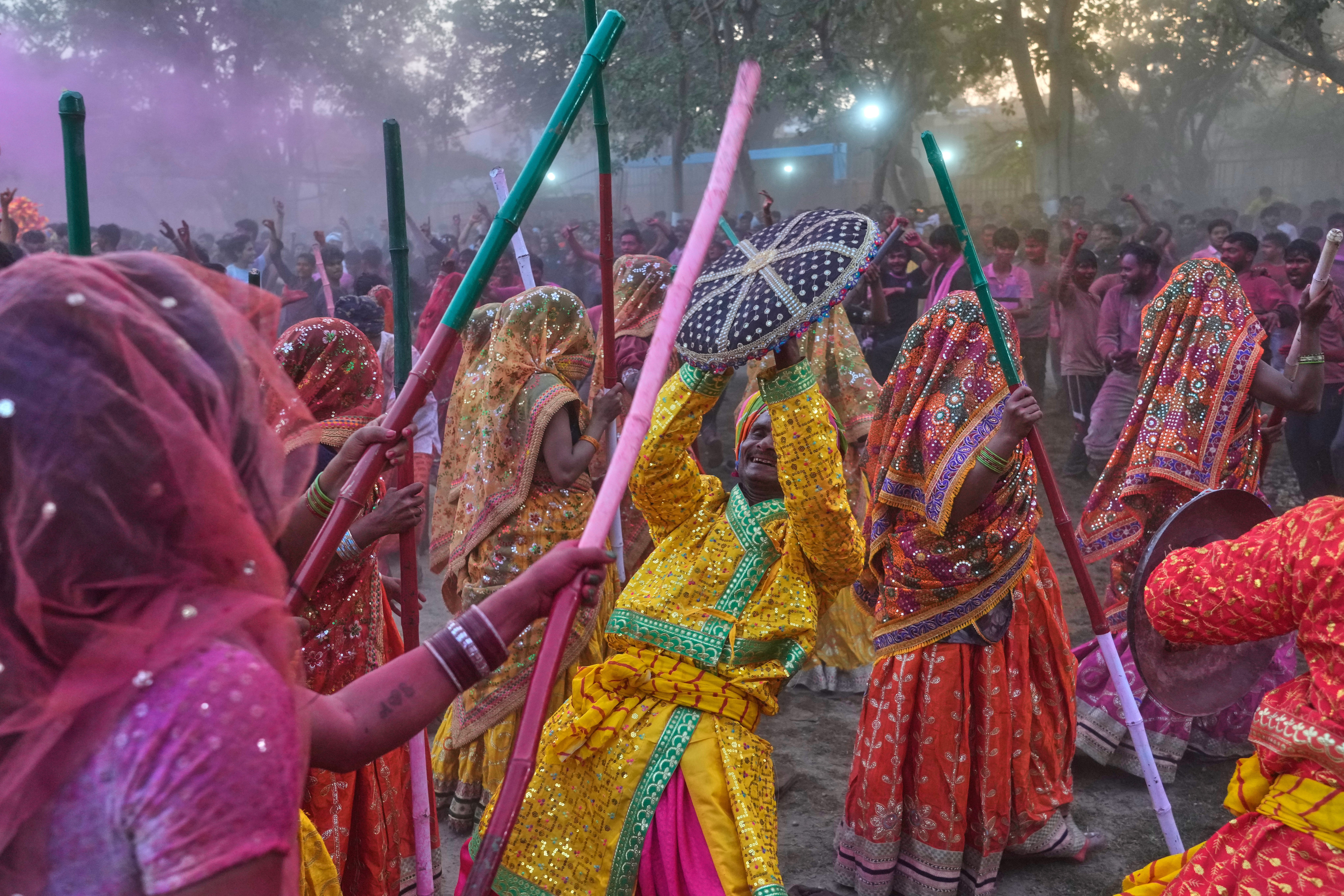 Devotas golpean simbólicamente a hombres con palos de madera durante el Lathmar Holi, en las celebraciones del festival en el complejo del Templo Shri Krishna Janmabhoomi, en Mathura, India