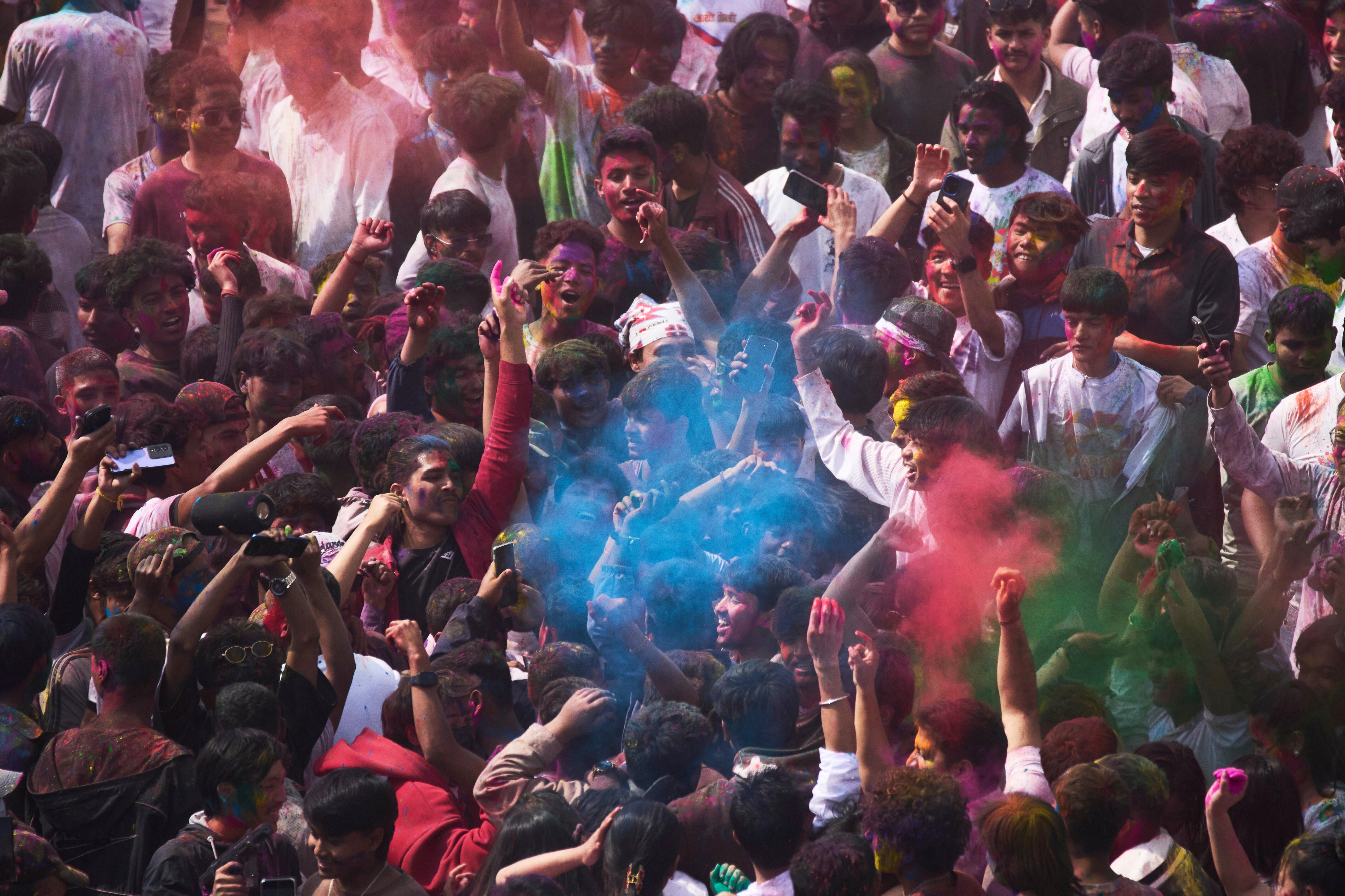 Nepalíes se arrojan polvos de colores mientras celebran Holi, el festival hindú de los colores, en la plaza Basantapur Durbar, en Katmandú, Nepal