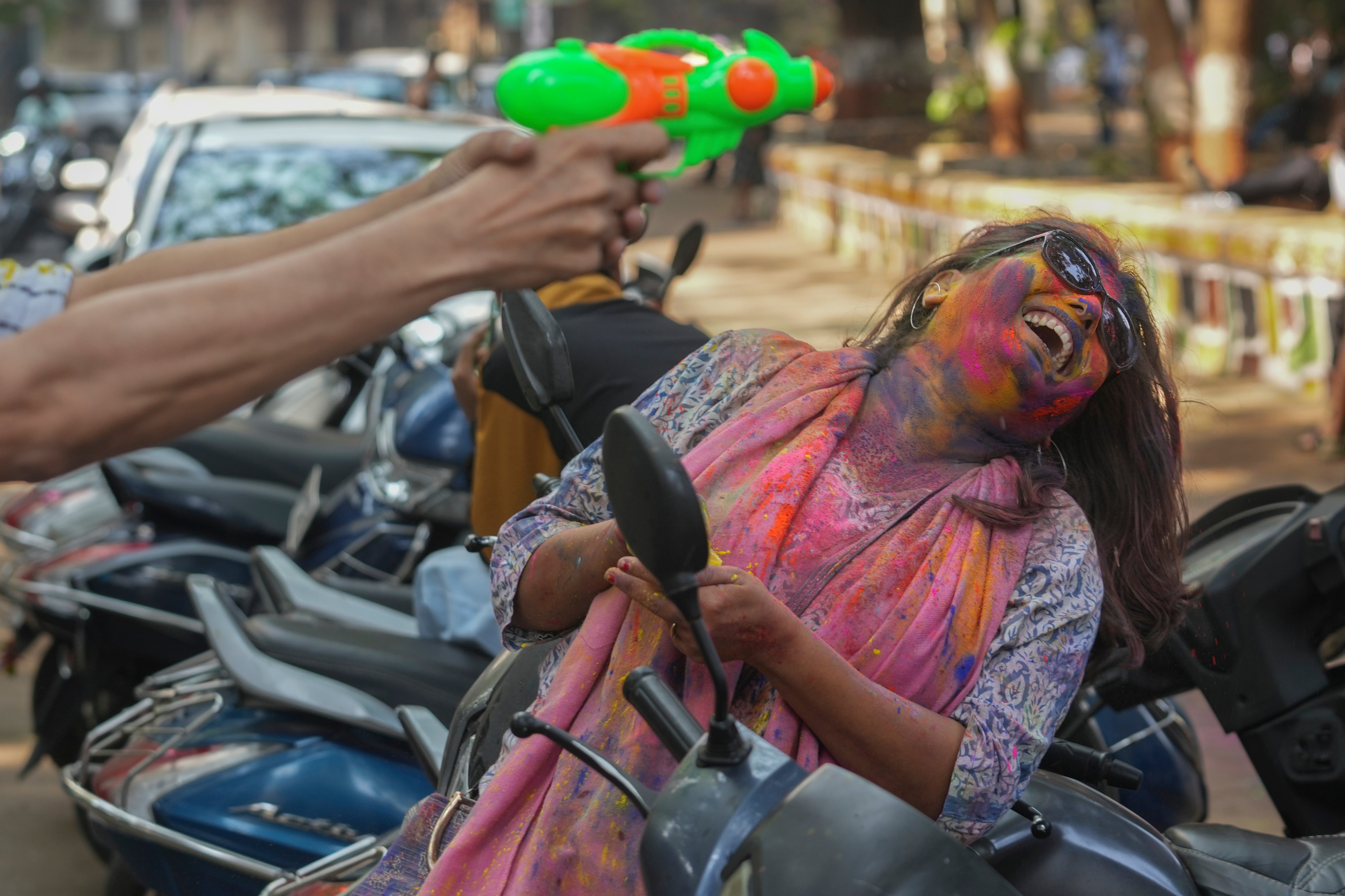 Una mujer con la cara embadurnada de polvos de colores celebra Holi en Bombay