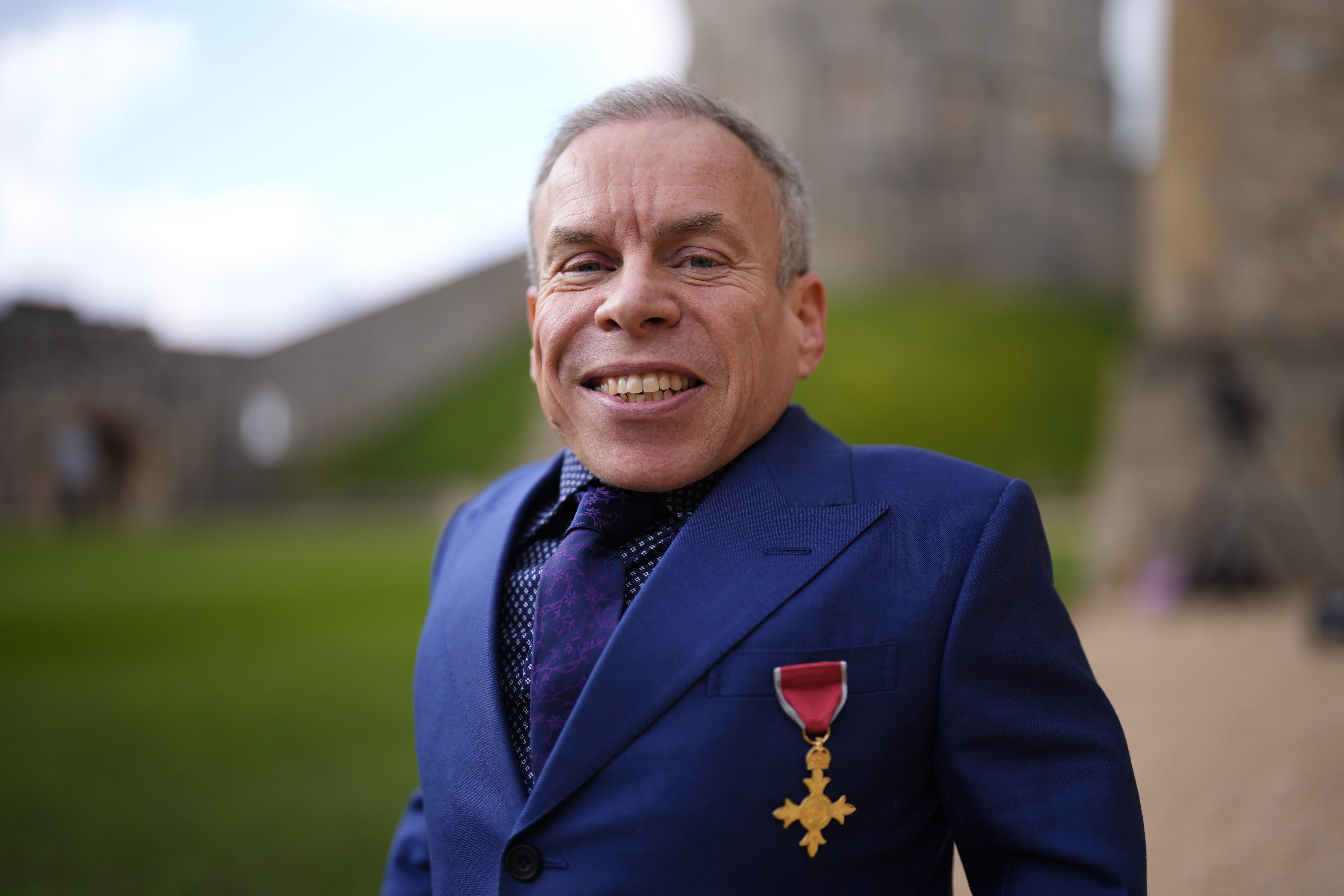 Warwick Davis tras recibir el título de Oficial de la Orden del Imperio Británico (OBE) en una ceremonia de investidura celebrada en el castillo de Windsor
