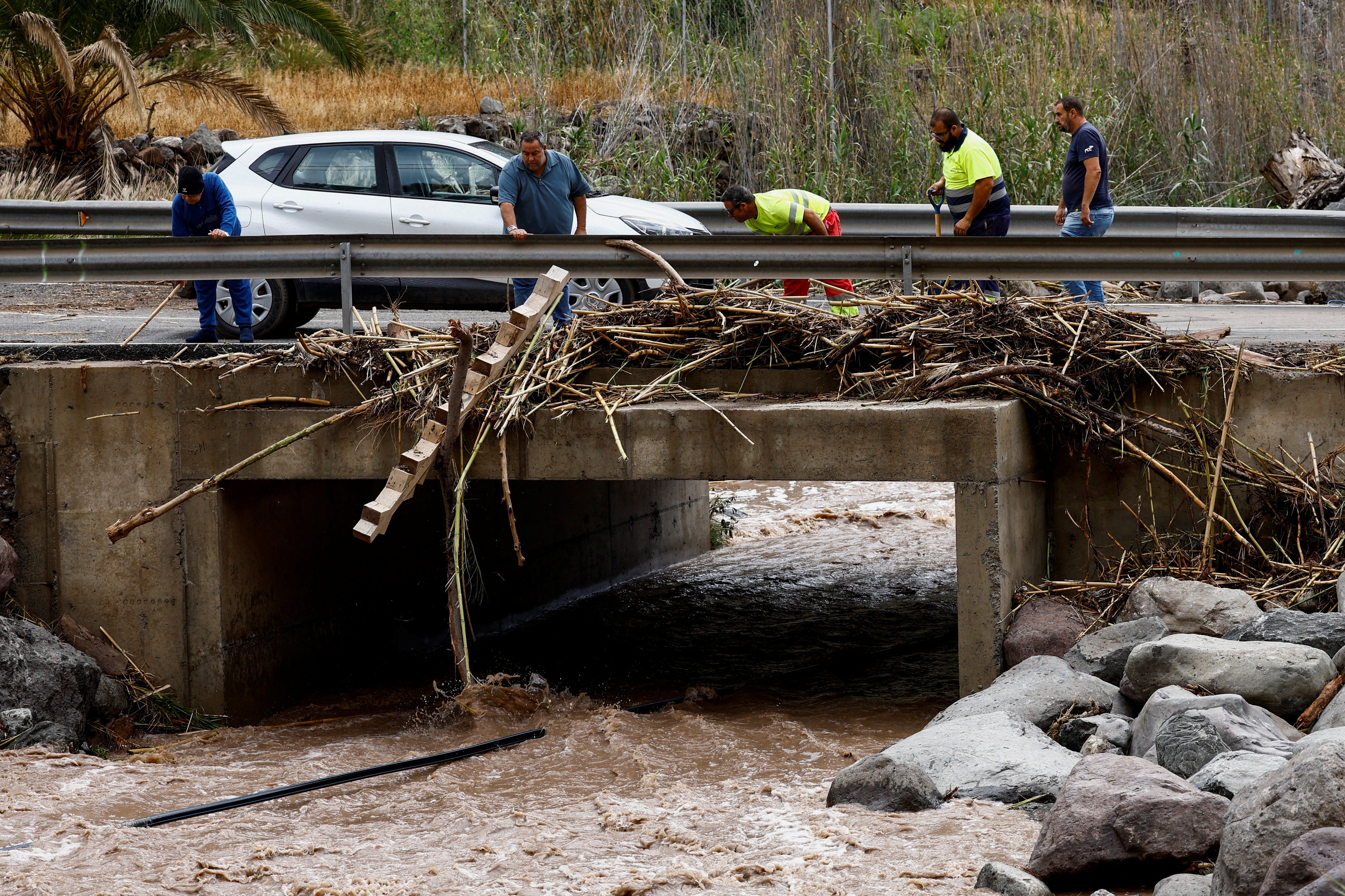 La gente despeja las carreteras en Cercados de Espino, en la isla de Gran Canaria, tras las fuertes lluvias (Reuters).