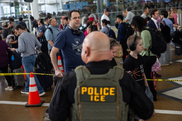 <p>Unos viajeros esperan en fila en el Aeropuerto Intercontinental George Bush de Houston bajo la mirada de un agente del ICE, el 24 de marzo de 2026, en medio de un cierre parcial del Gobierno que está provocando escenas similares en todo el país</p>
