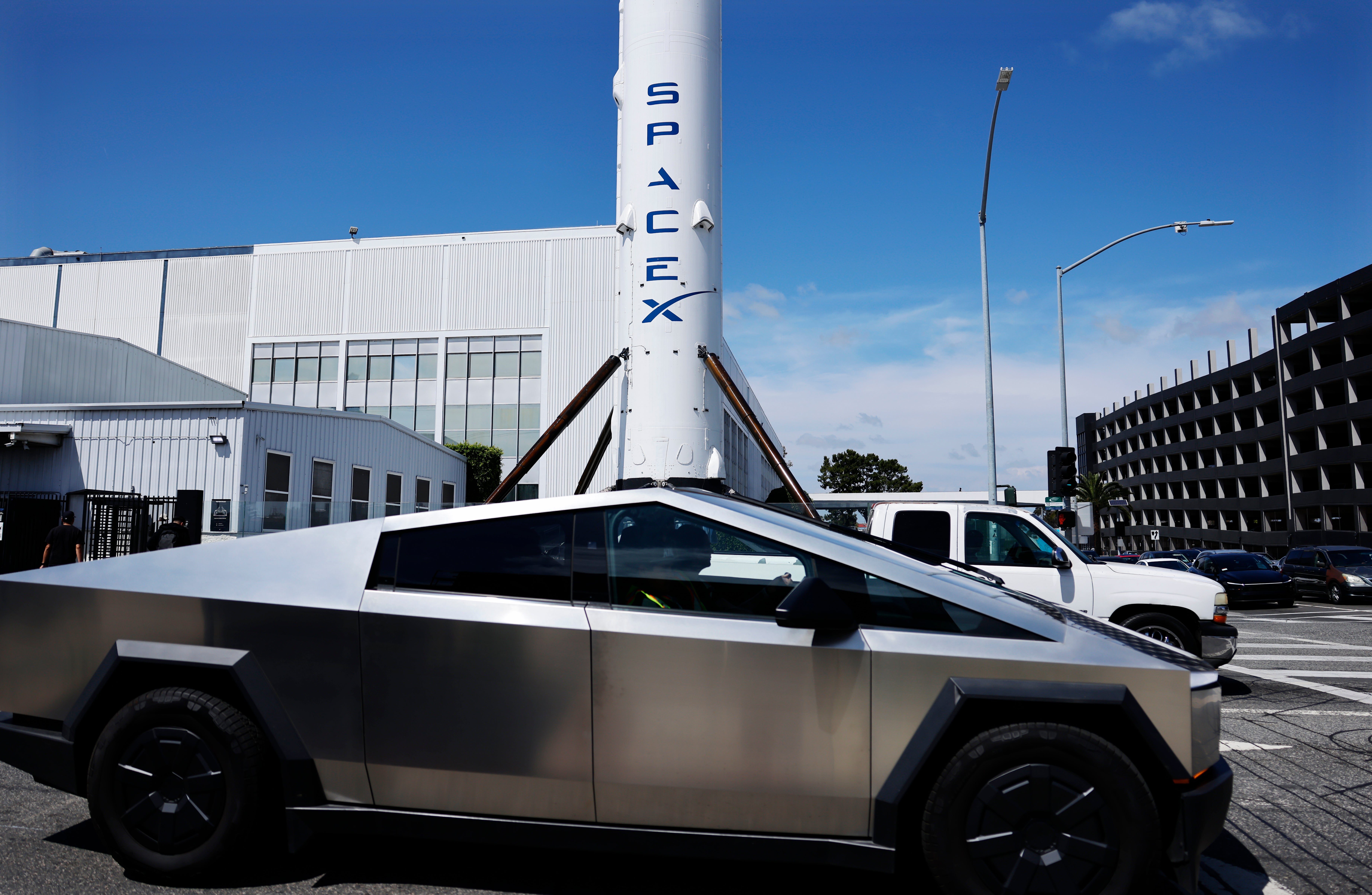 Un Tesla Cybertruck pasa junto a un cohete Falcon 9 de SpaceX expuesto en una instalación de la compañía el 2 de abril de 2026 en Hawthorne, California