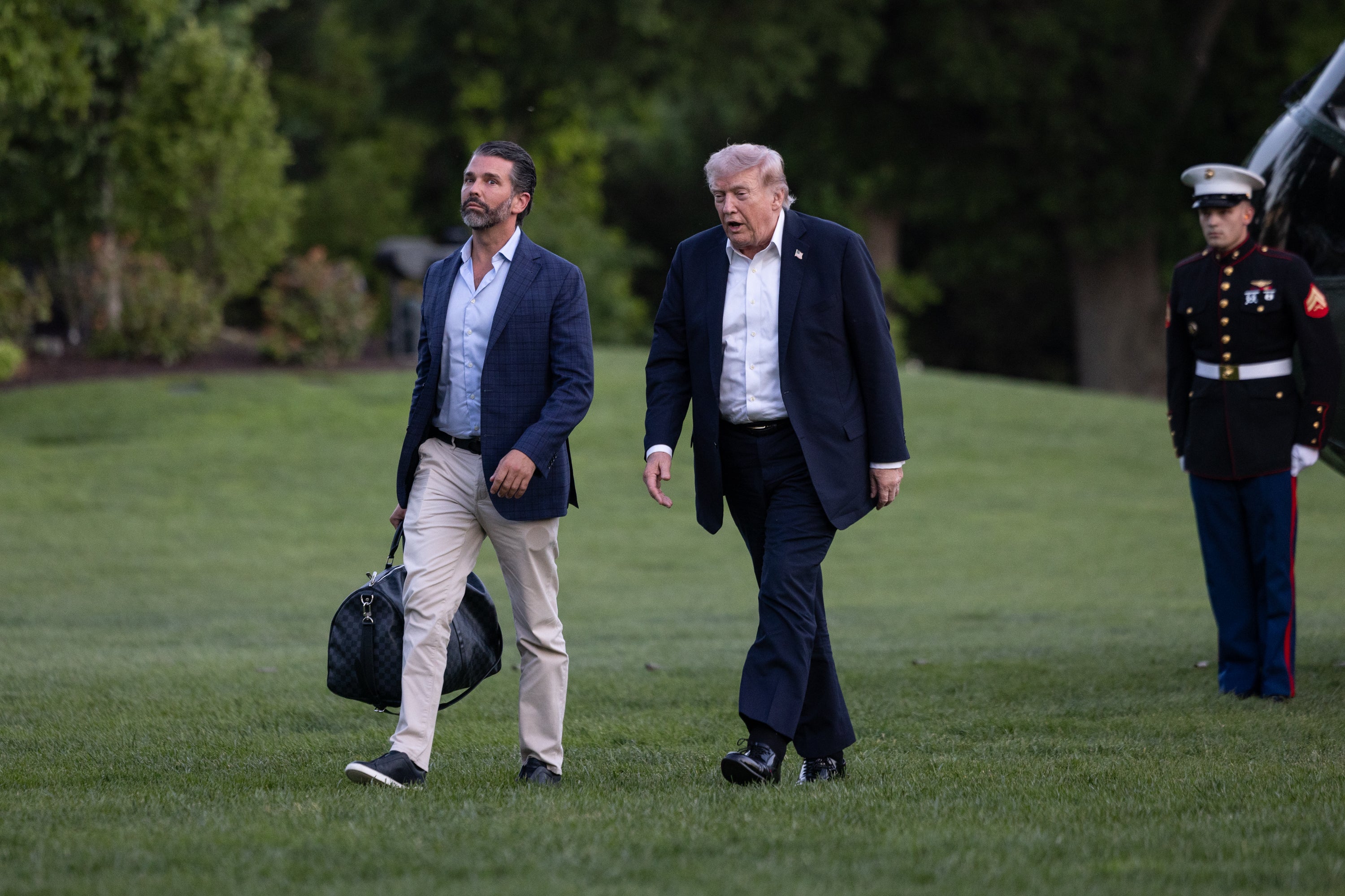 El presidente Donald Trump y su hijo Donald Trump Jr. caminan por el jardín sur de la Casa Blanca. Trump visitó a un dentista en Florida durante el fin de semana y, a su regreso, fue visto con aparentes tobillos hinchados