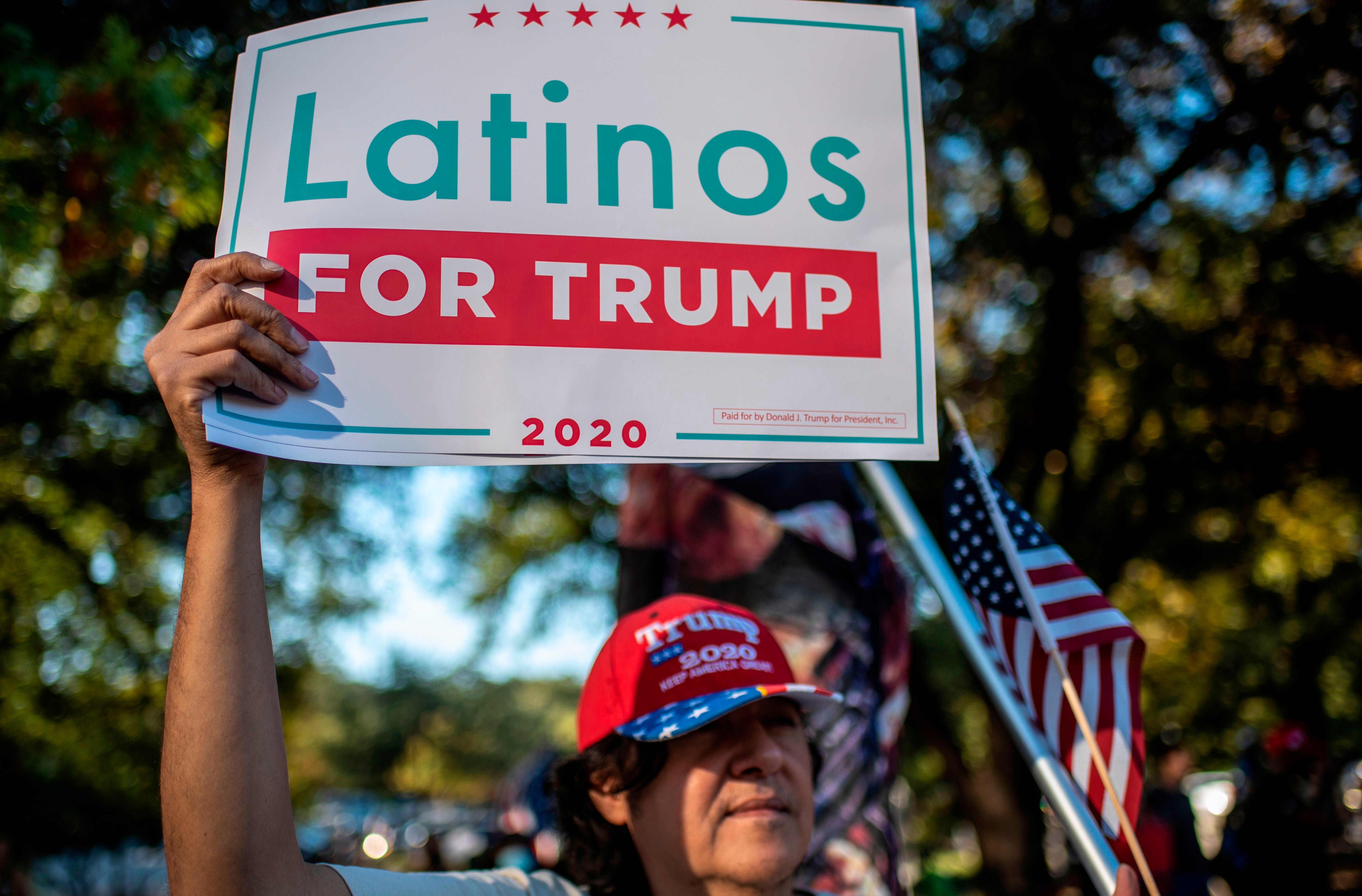 A man holds up a "Latinos for Trump" sign at a protest after Joe Biden won the 2020 presidential election in Austin, Texas on November 7, 2020. - Democrat Joe Biden has won the White House, US media said November 7, defeating Donald Trump and ending a presidency that convulsed American politics, shocked the world and left the United States more divided than at any time in decades. (Photo by Sergio FLORES / AFP) (Photo by SERGIO FLORES/AFP via Getty Images)