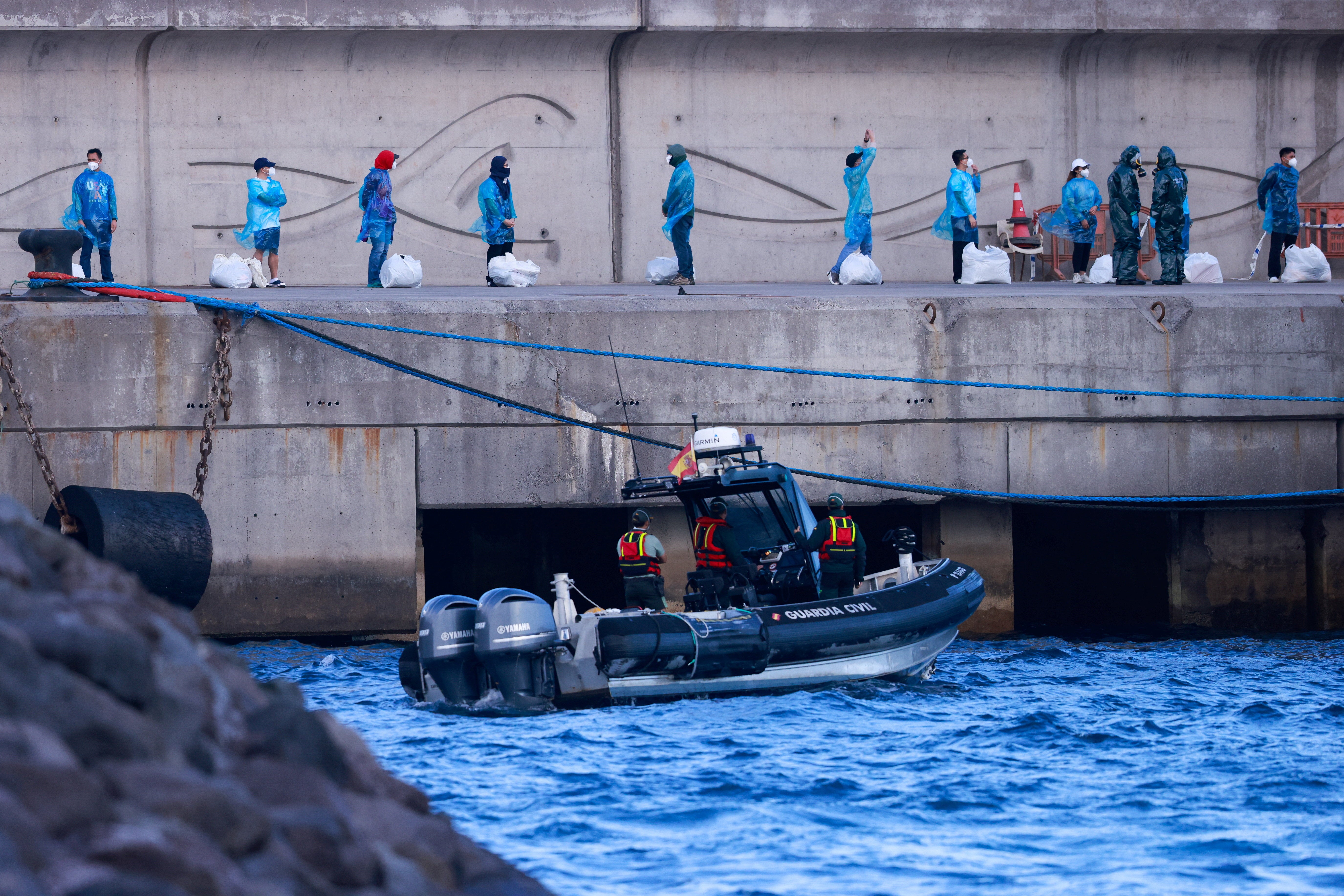Tourists wait at the dock after disembarking from the cruise ship MV Hondius, affected by a hantavirus outbreak, at the port of Granadilla de Abona, Tenerife, Spain May 11, 2026