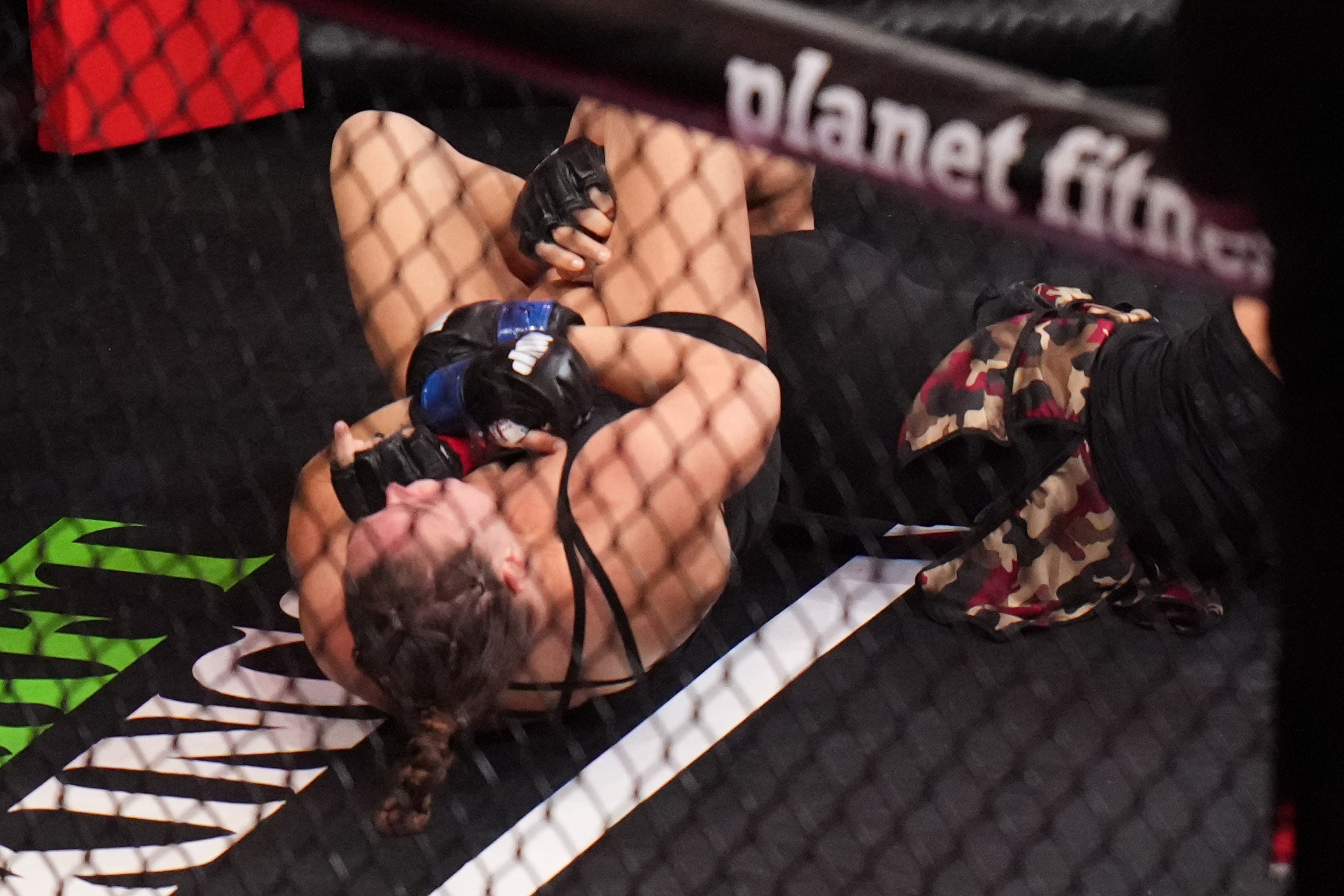 Ronda Rousey usando una llave de brazo con Gina Carano