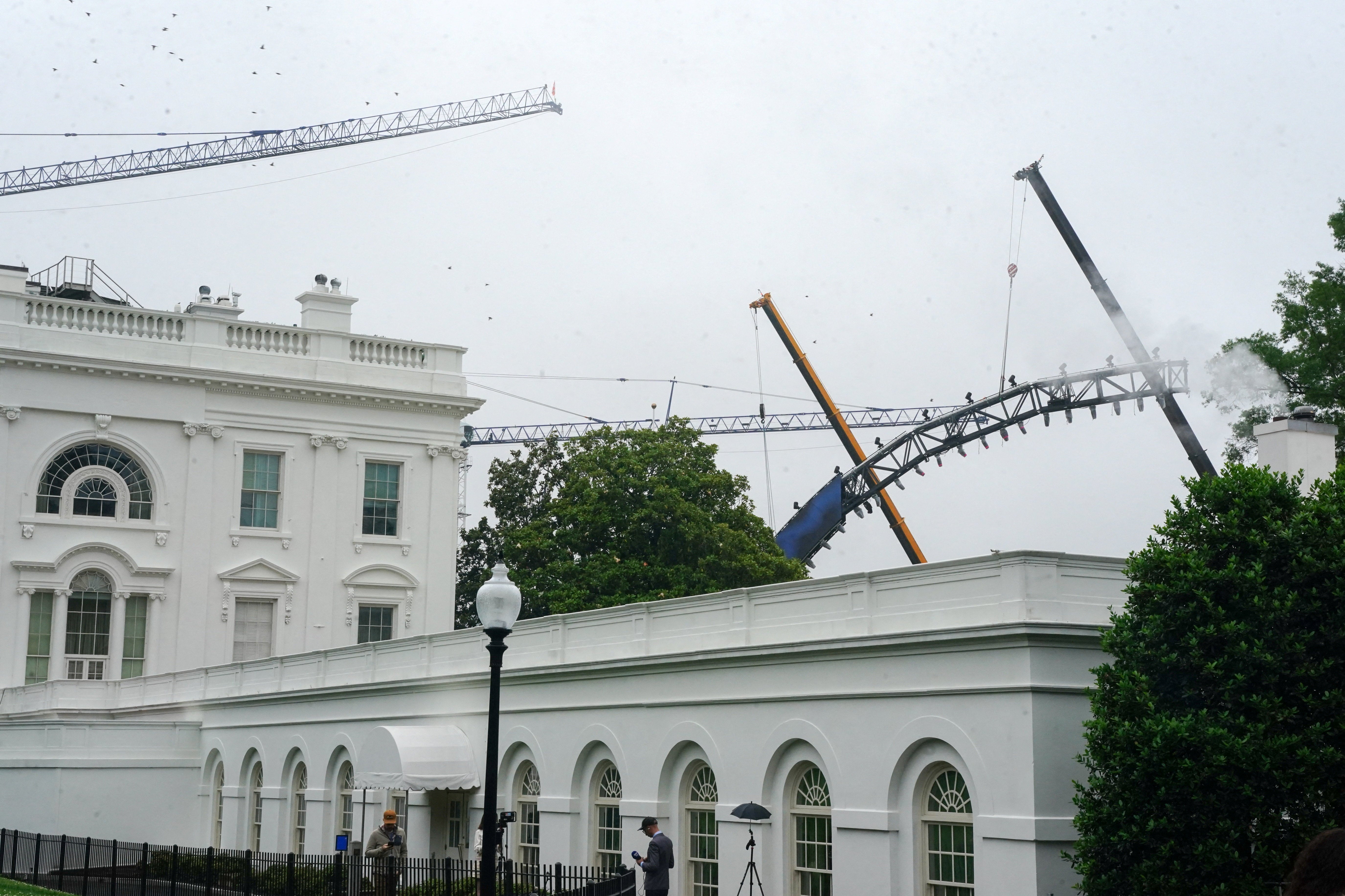 En una fotografía tomada el lunes, se observa a varias grúas transportando una sección de la estructura frente a la Casa Blanca