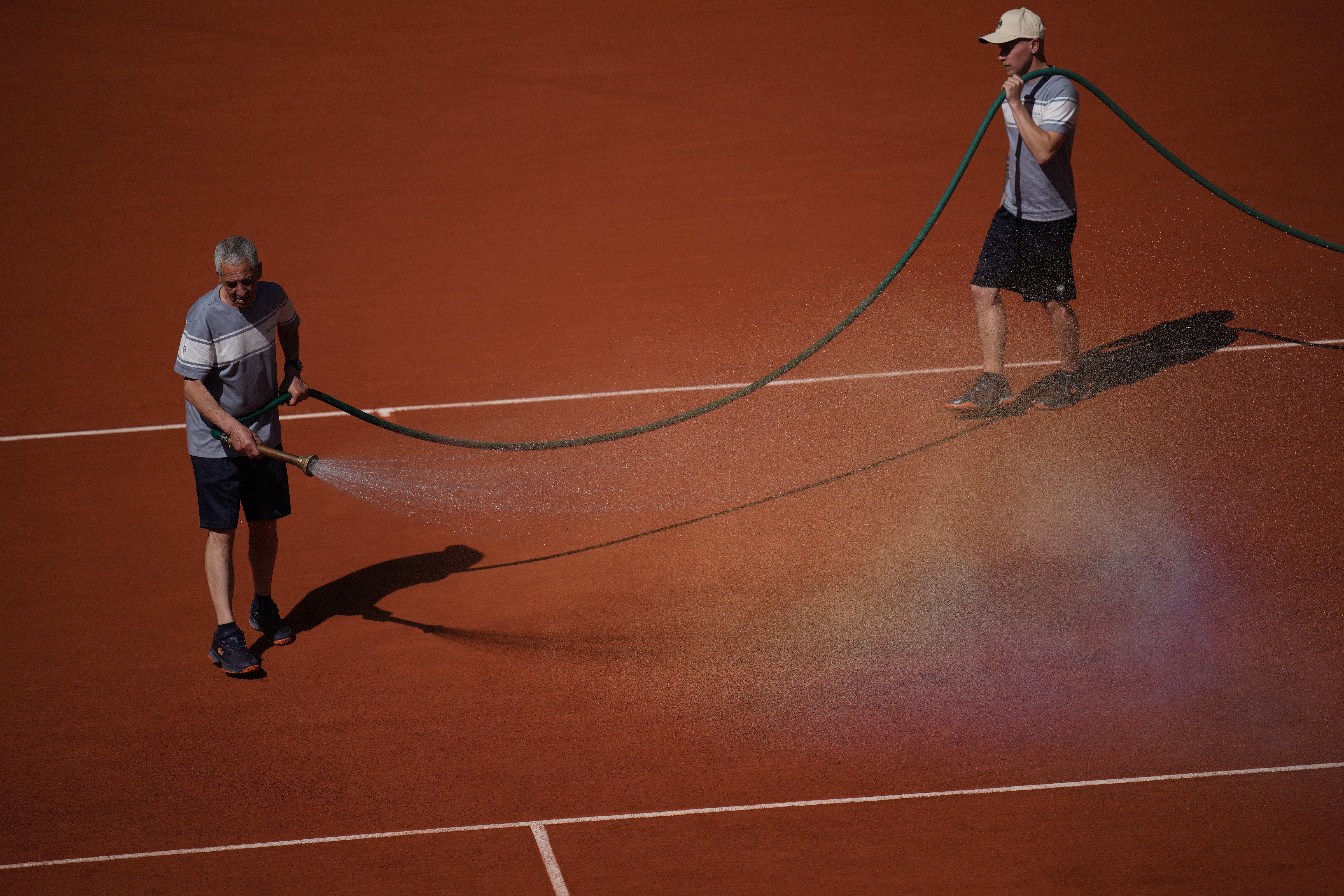Jardineros de Roland Garros empapan las canchas de arcilla con agua y sal por ola de calor
