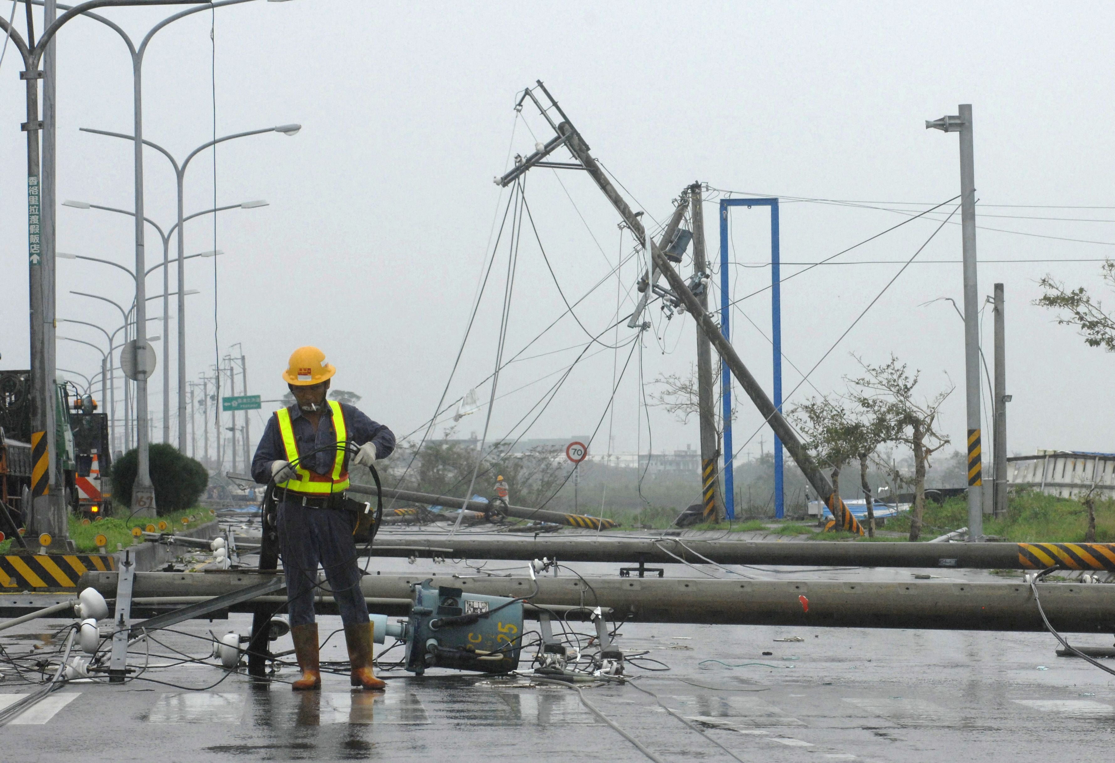 Unos trabajadores intentan reparar las líneas eléctricas y los postes derribados por el tifón Jaigmi en Suao, una localidad costera del condado de Ilan, en el noreste de Taiwán