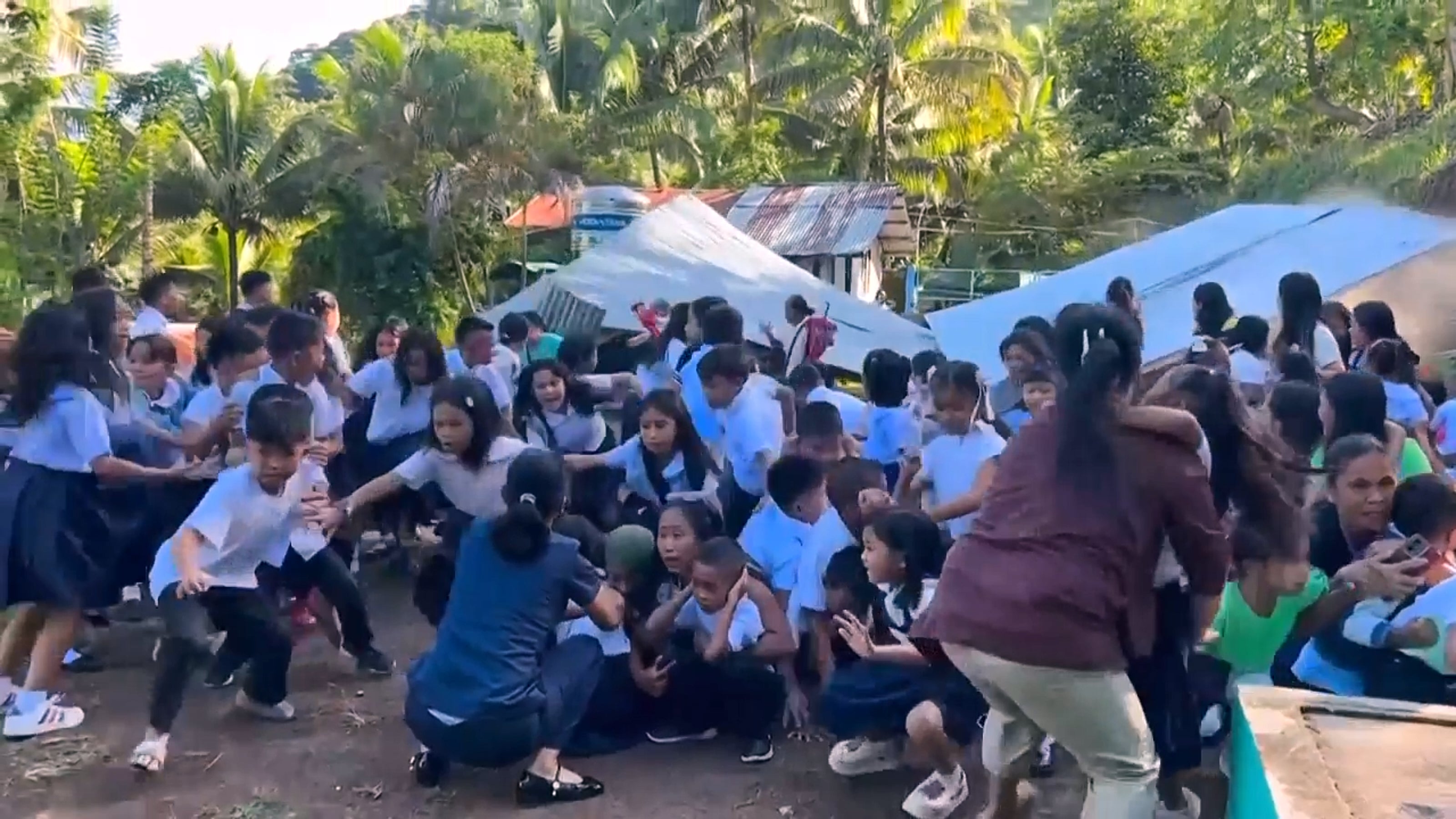Niños reaccionan tras el colapso del techo de una estructura provocado por el terremoto en Malita, provincia de Davao Occidental, el 8 de junio de 2026