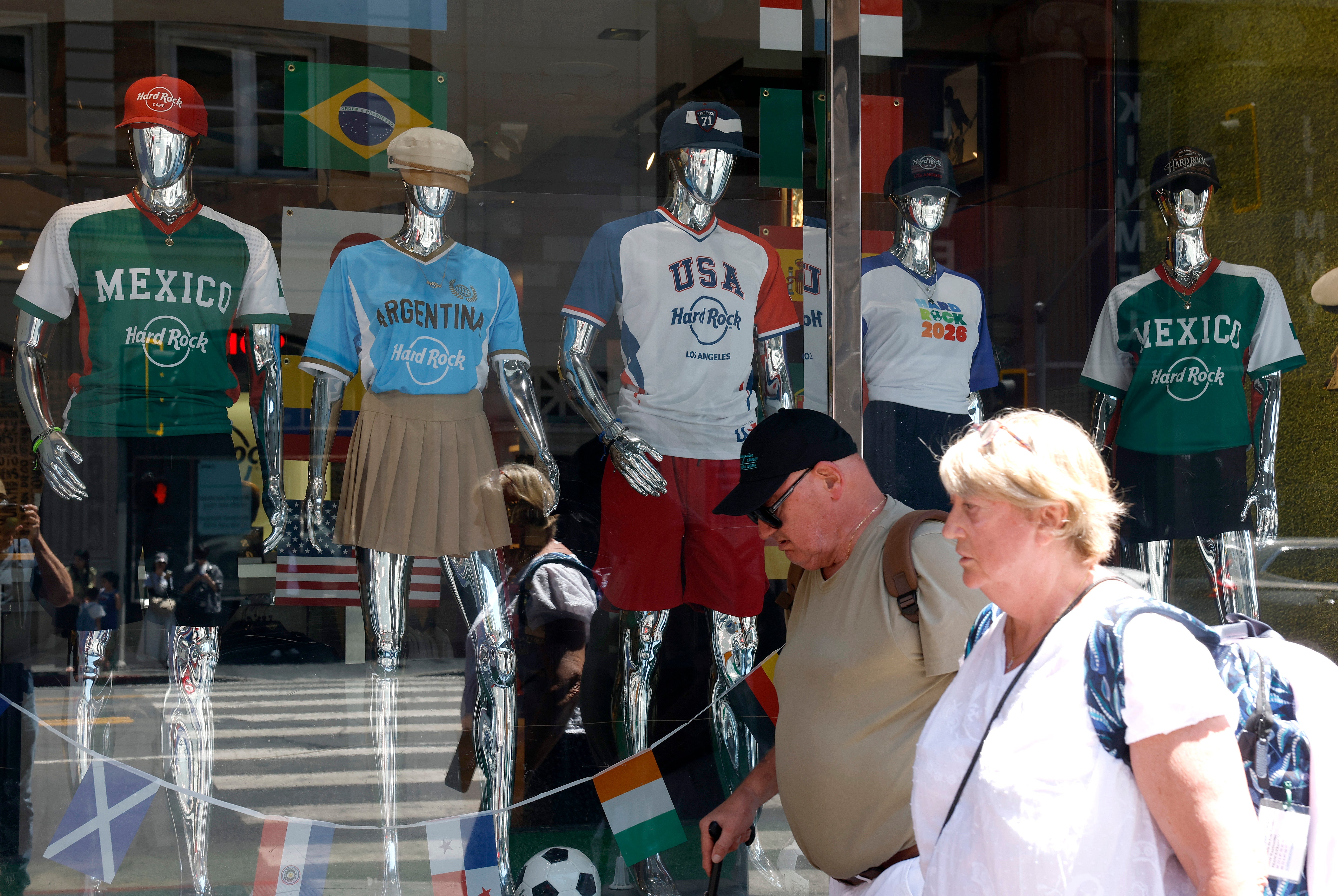 Dos estadounidenses pasan junto a una vitrina de camisetas del Mundial en Santa Mónica, California, EE. UU. Más de cuatro de cada diez estadounidenses afirmaron en una encuesta reciente que no les interesaba el Mundial de 2026