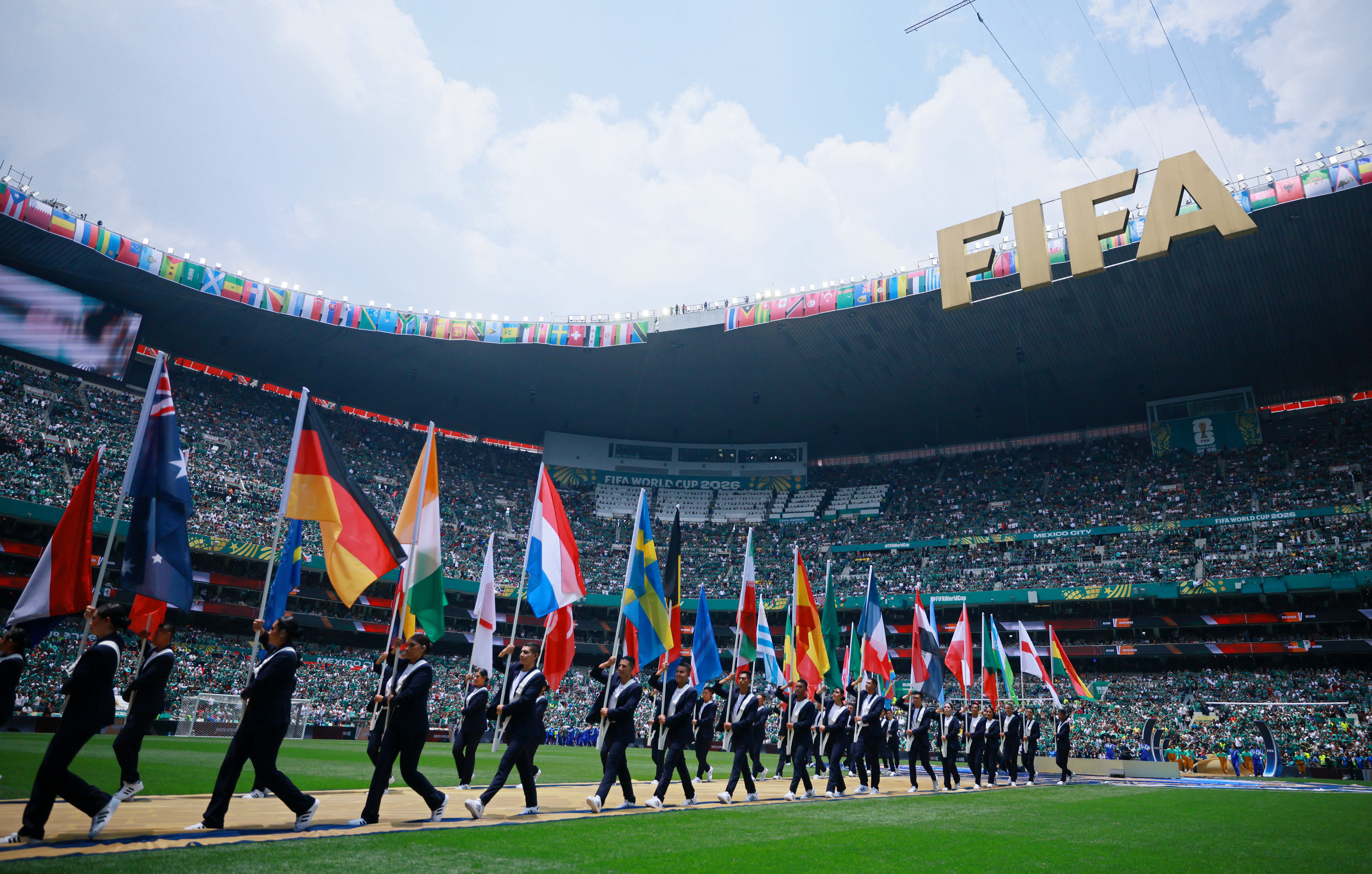 Las banderas de los 48 equipos fueron exhibidas sobre el terreno de juego antes del inicio del partido