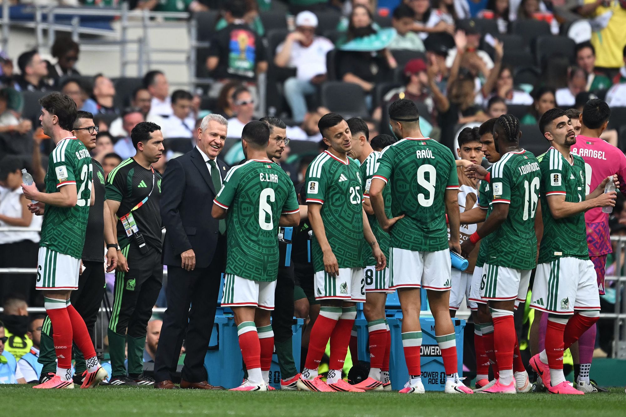 El seleccionador de México, Javier Aguirre, habla con sus jugadores durante el descanso para hidratarse