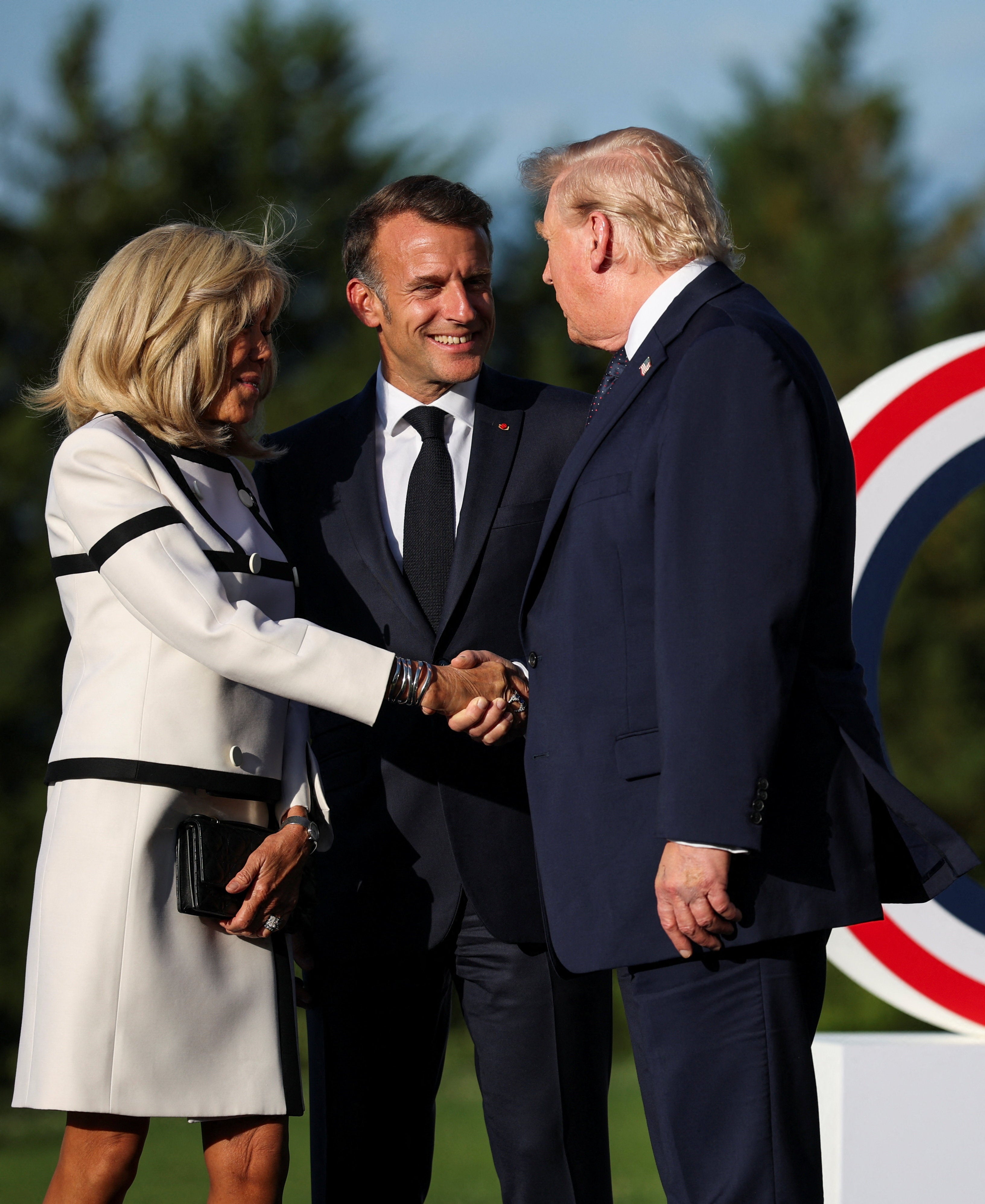 Trump le da a Brigitte Macron un largo apretón de manos durante la cumbre del G7 tras burlarse de su matrimonio