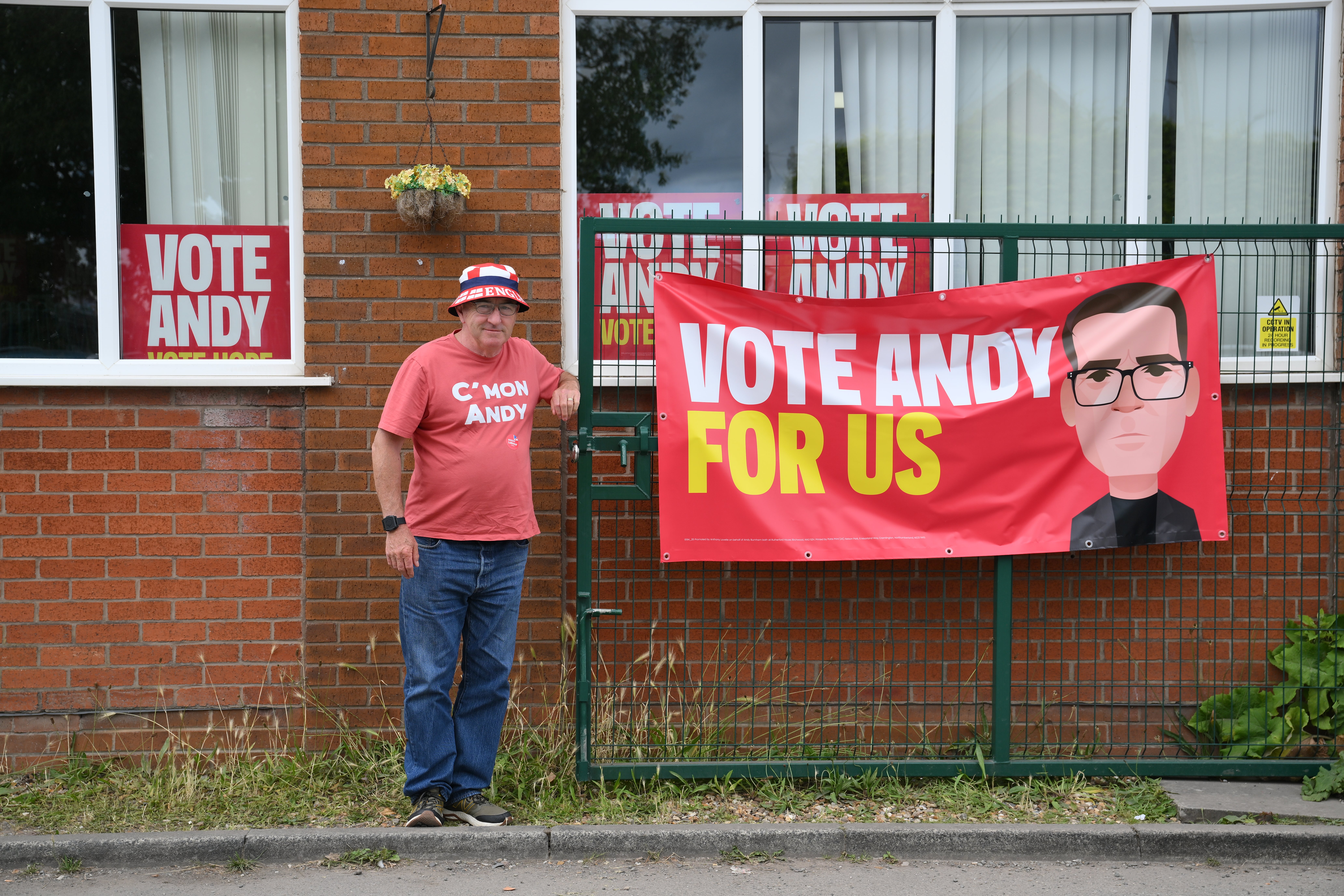 Un simpatizante de Andy Burnham posa junto a una pancarta en el Community Sports Club de Makerfield, en el Gran Mánchester