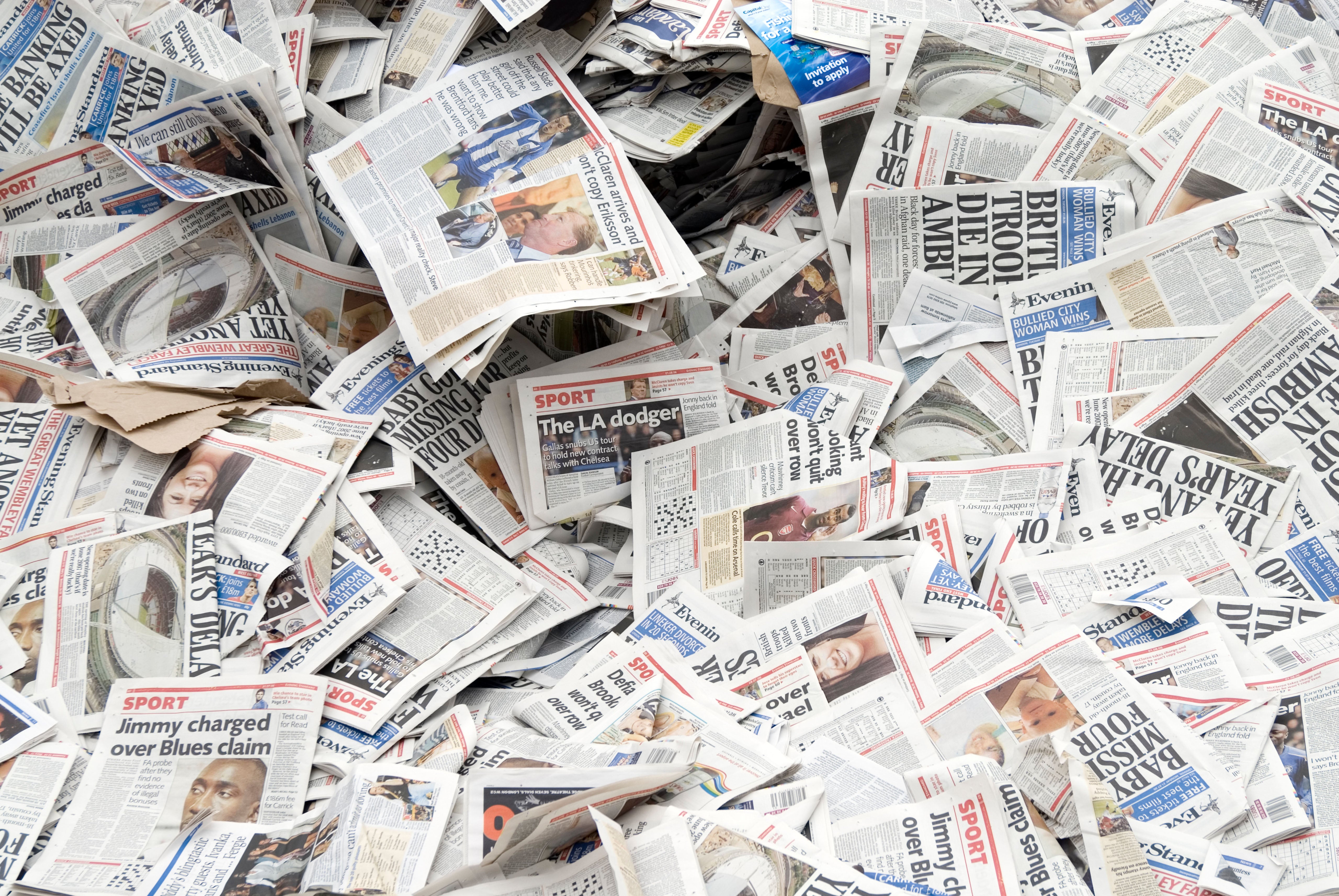 Recupera algunos periódicos viejos del contenedor de reciclaje