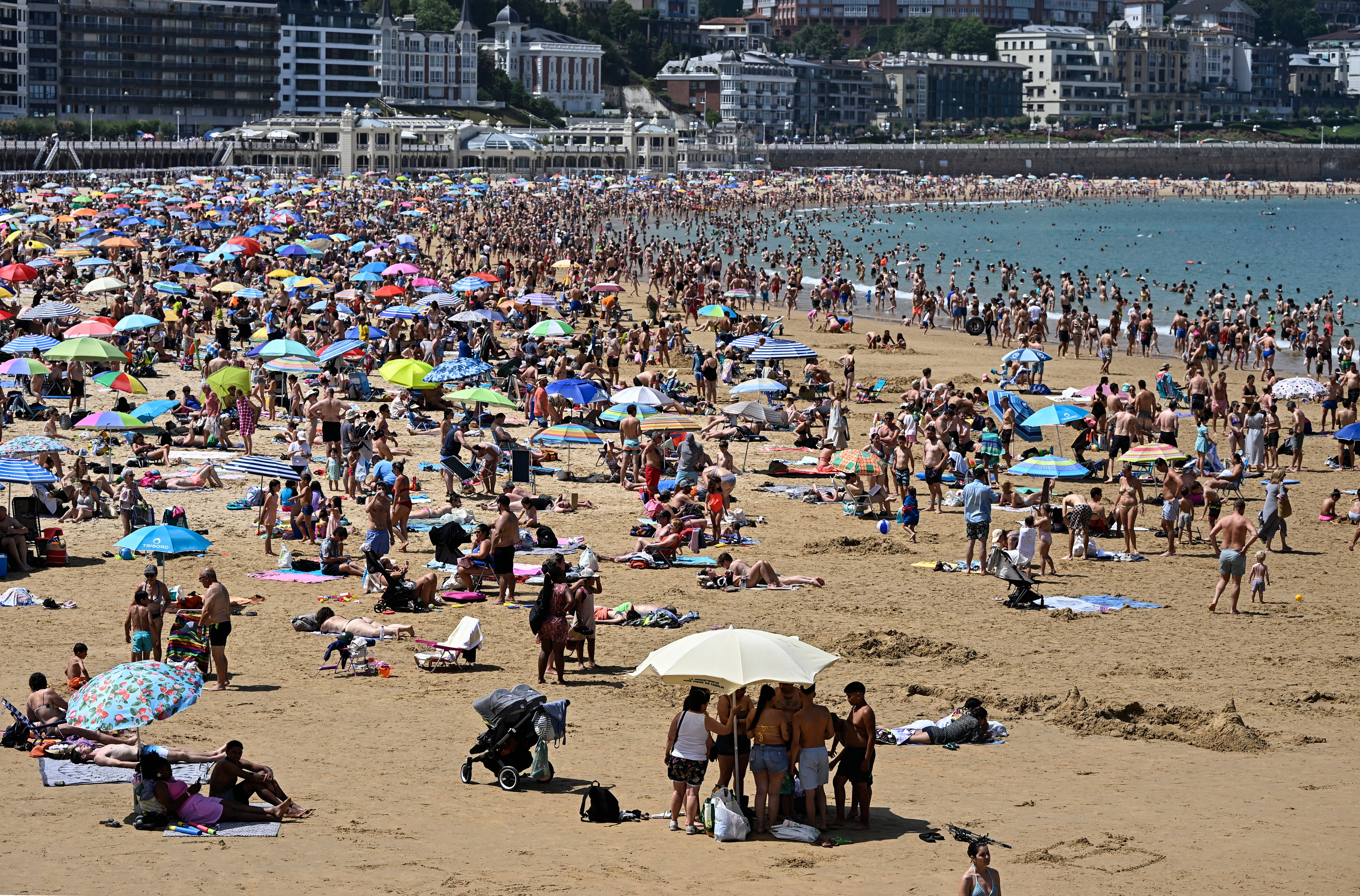 La gente llena la playa de La Concha en la ciudad vasca española de San Sebastián, el 21 de junio de 2026, primer día de la primera ola de calor oficial de este verano