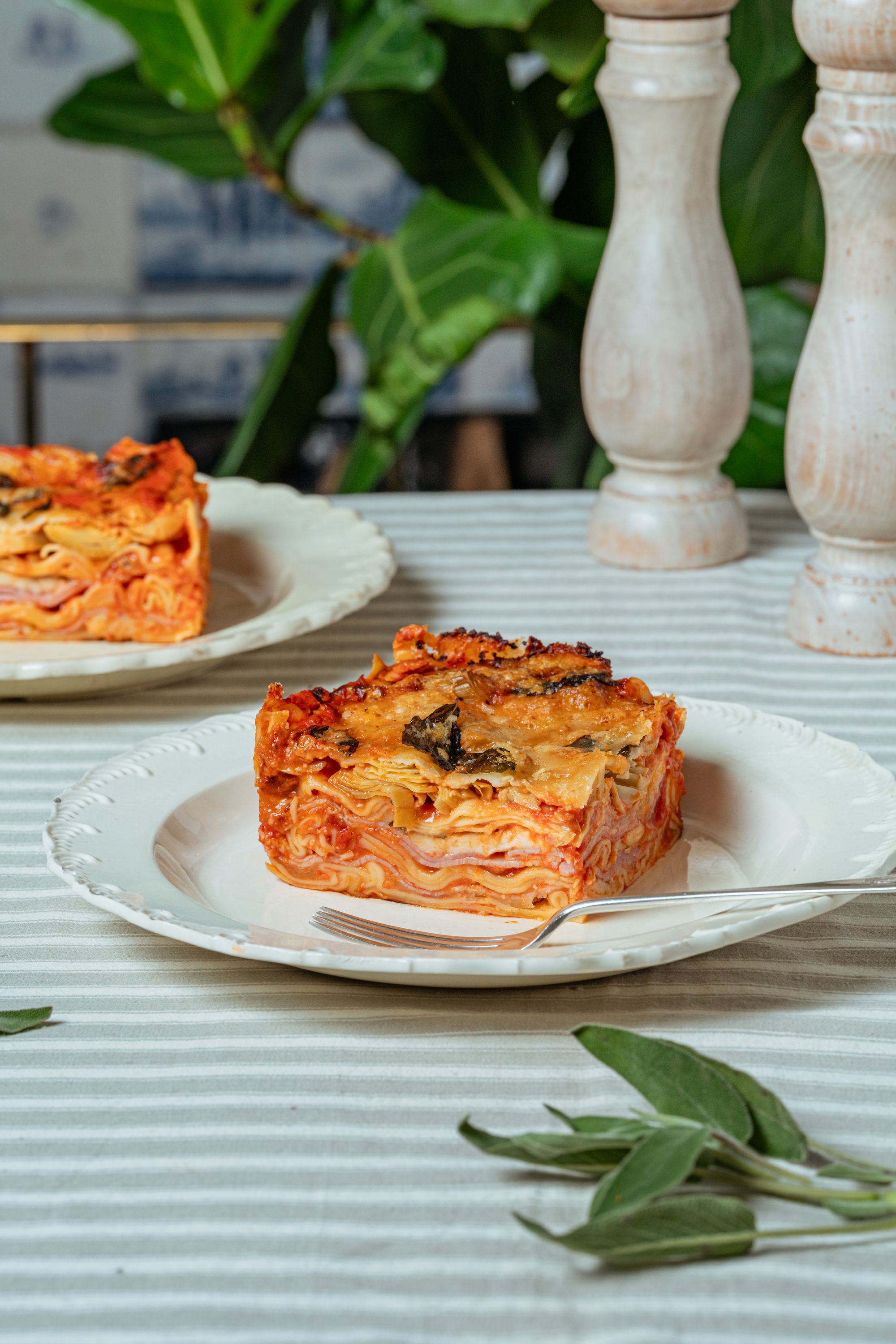 Una versión sencilla y reconfortante de la lasaña italiana, con jamón, alcachofas y abundante queso, ideal para compartir