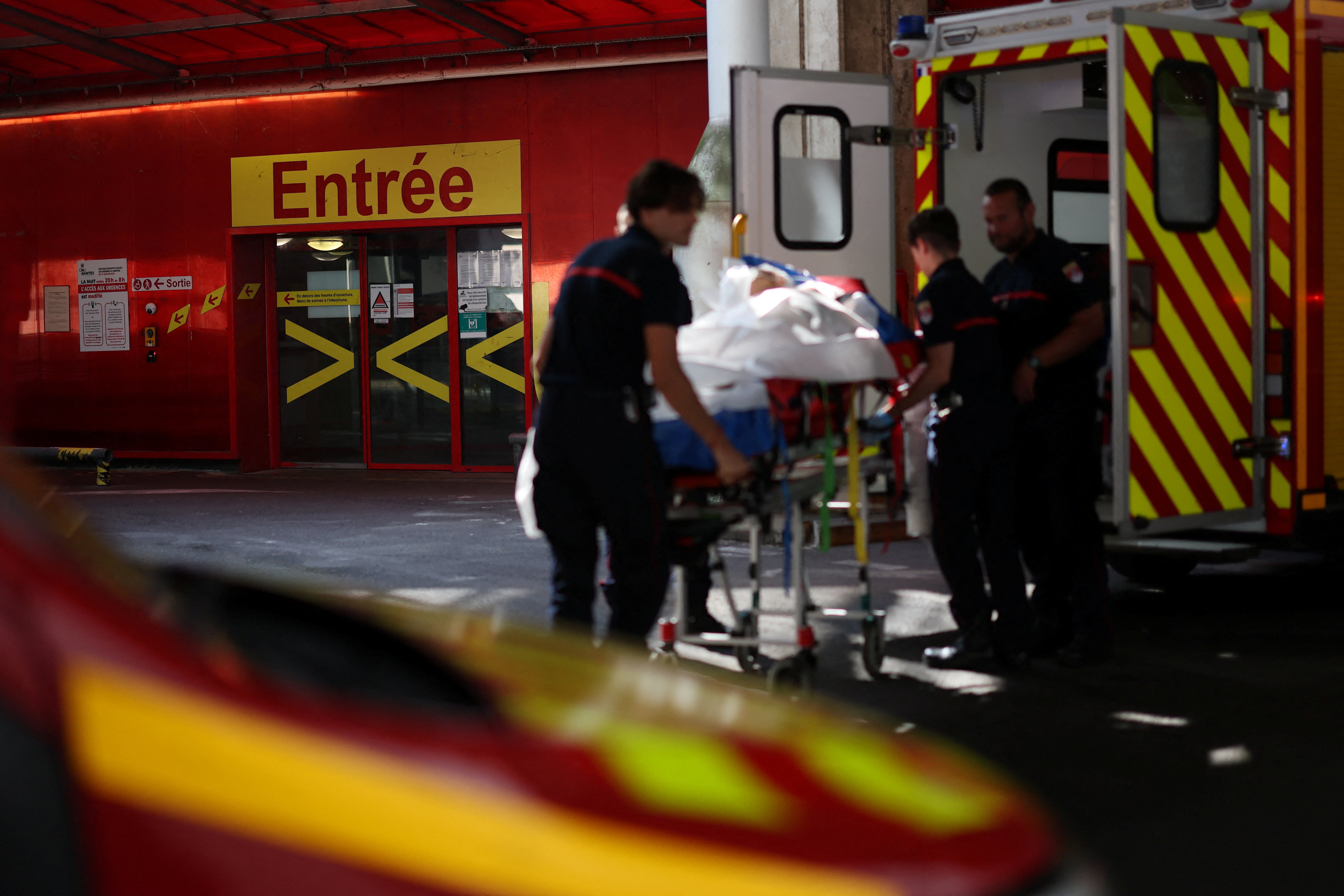 Bomberos franceses trasladan a un paciente en camilla en Nantes el 26 de junio, en medio de la intensa ola de calor que afecta al país