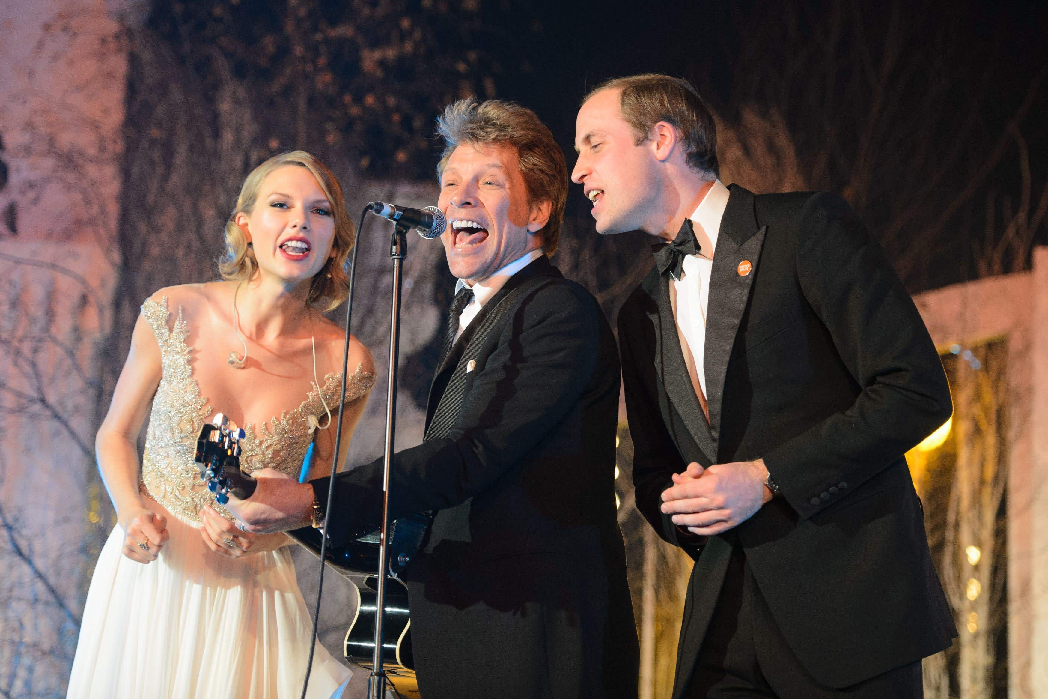 El príncipe William (a la derecha) canta con Taylor Swift (a la izquierda) y Jon Bon Jovi en la cena de gala de Centrepoint celebrada en el Palacio de Kensington, en Londres, en 2013