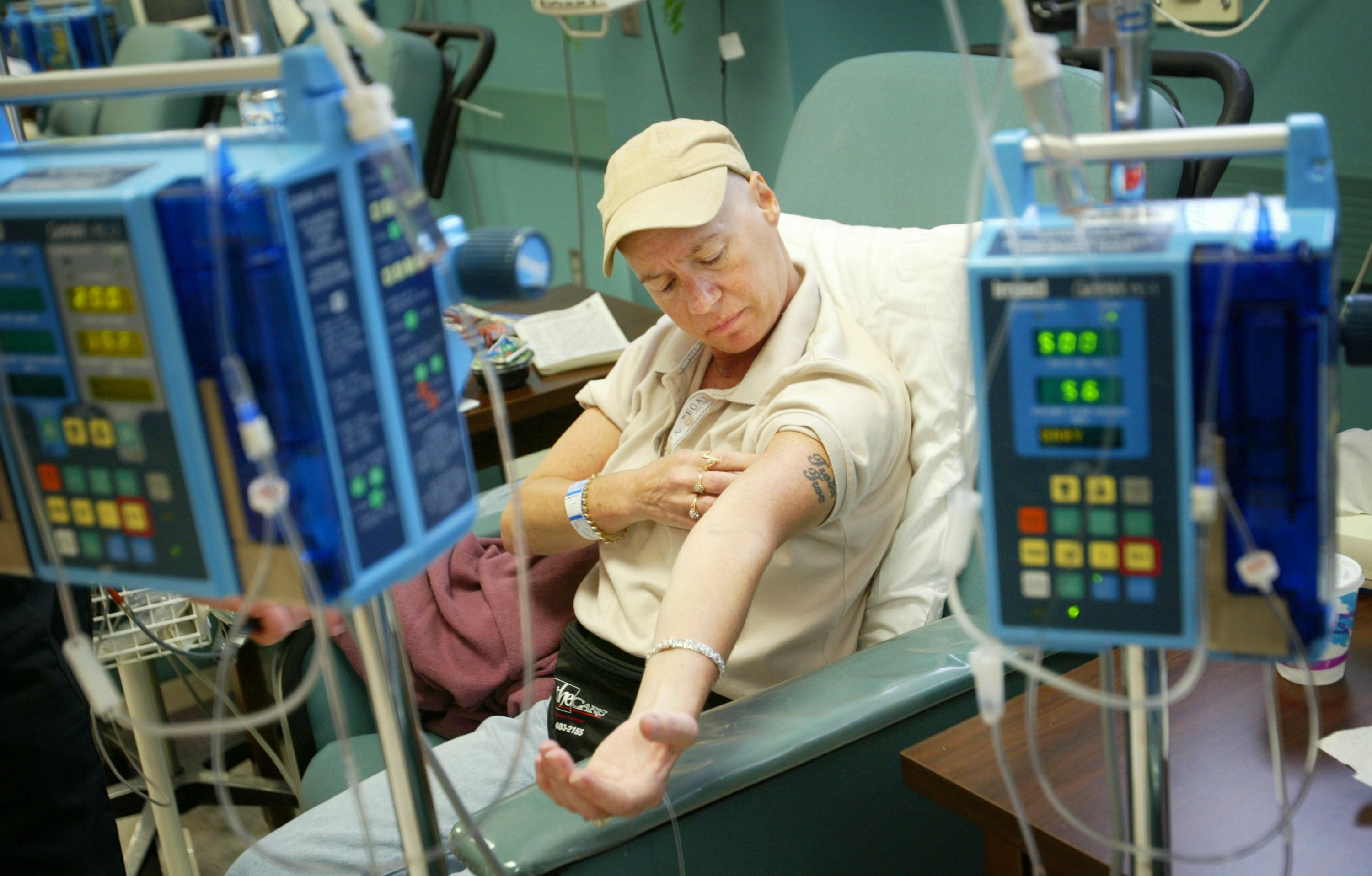 Ellen Walsh, paciente con cáncer, revisa su brazo durante una sesión de quimioterapia en Fayetteville, Carolina del Norte, en junio de 2003. El alto costo de la atención oncológica puede impedir que muchas personas en Estados Unidos accedan al tratamiento que necesitan